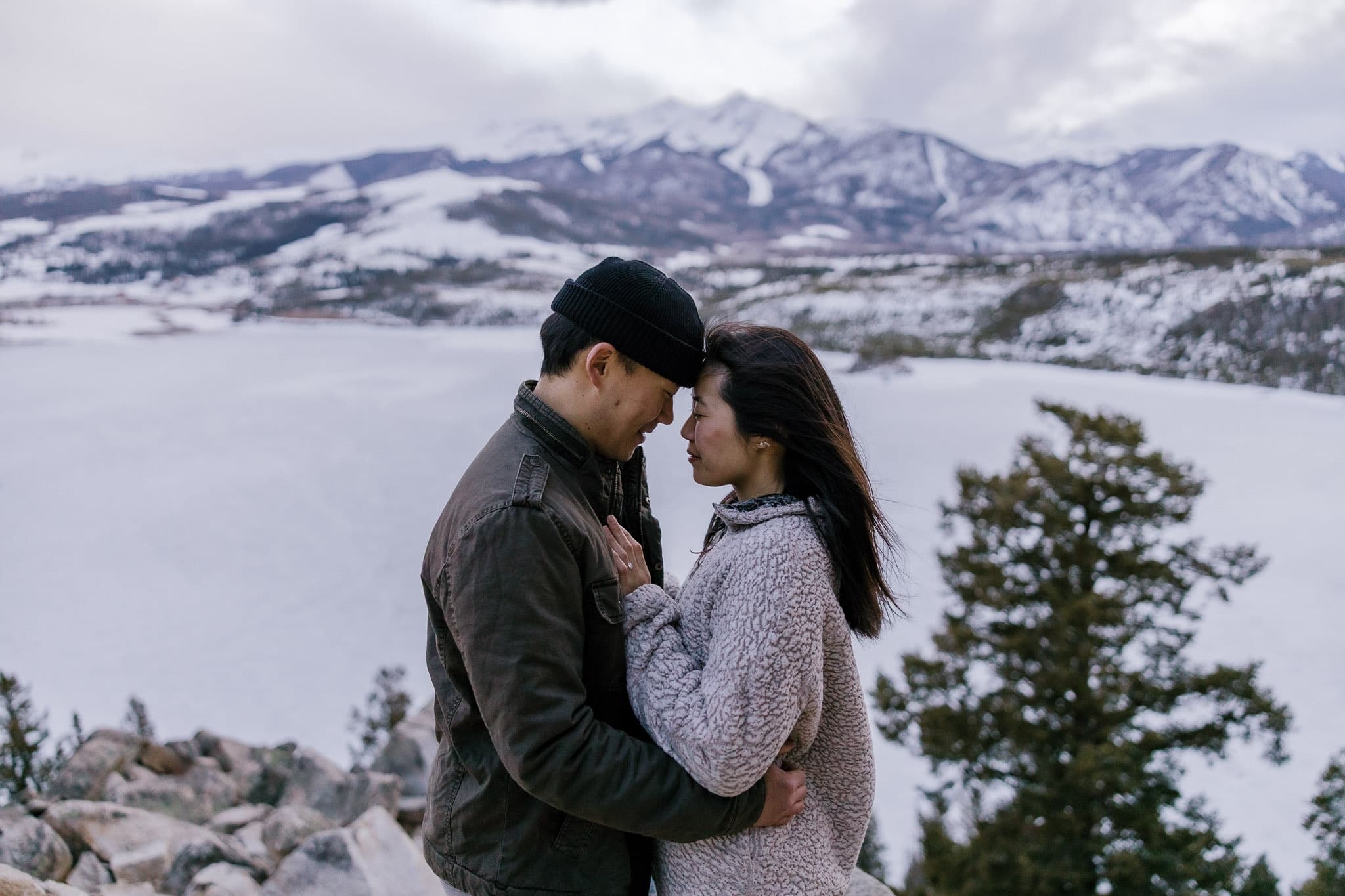 Couple embracing with snow-capped mountains across the lake