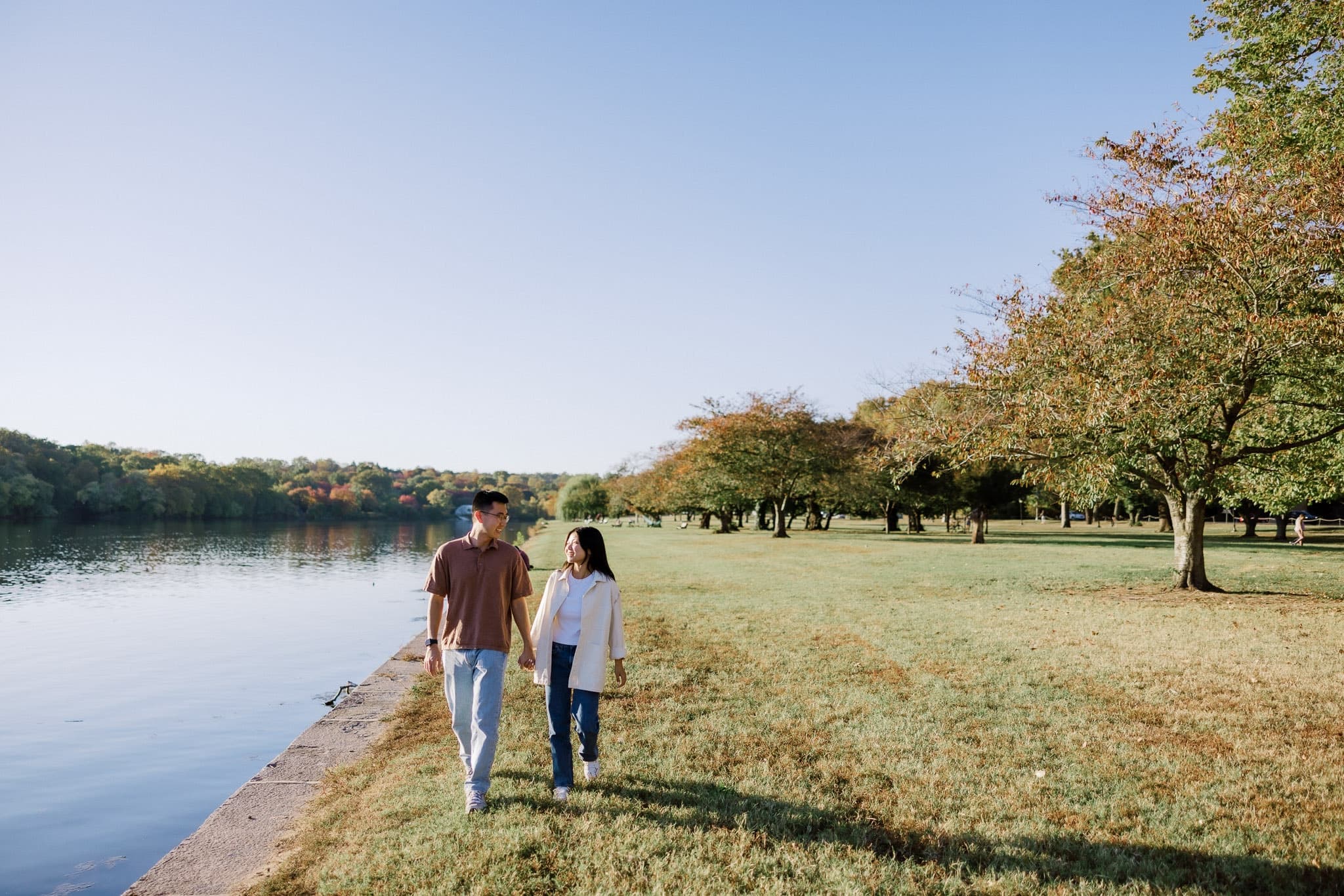 Couple walking hand in hand along the lakeshore