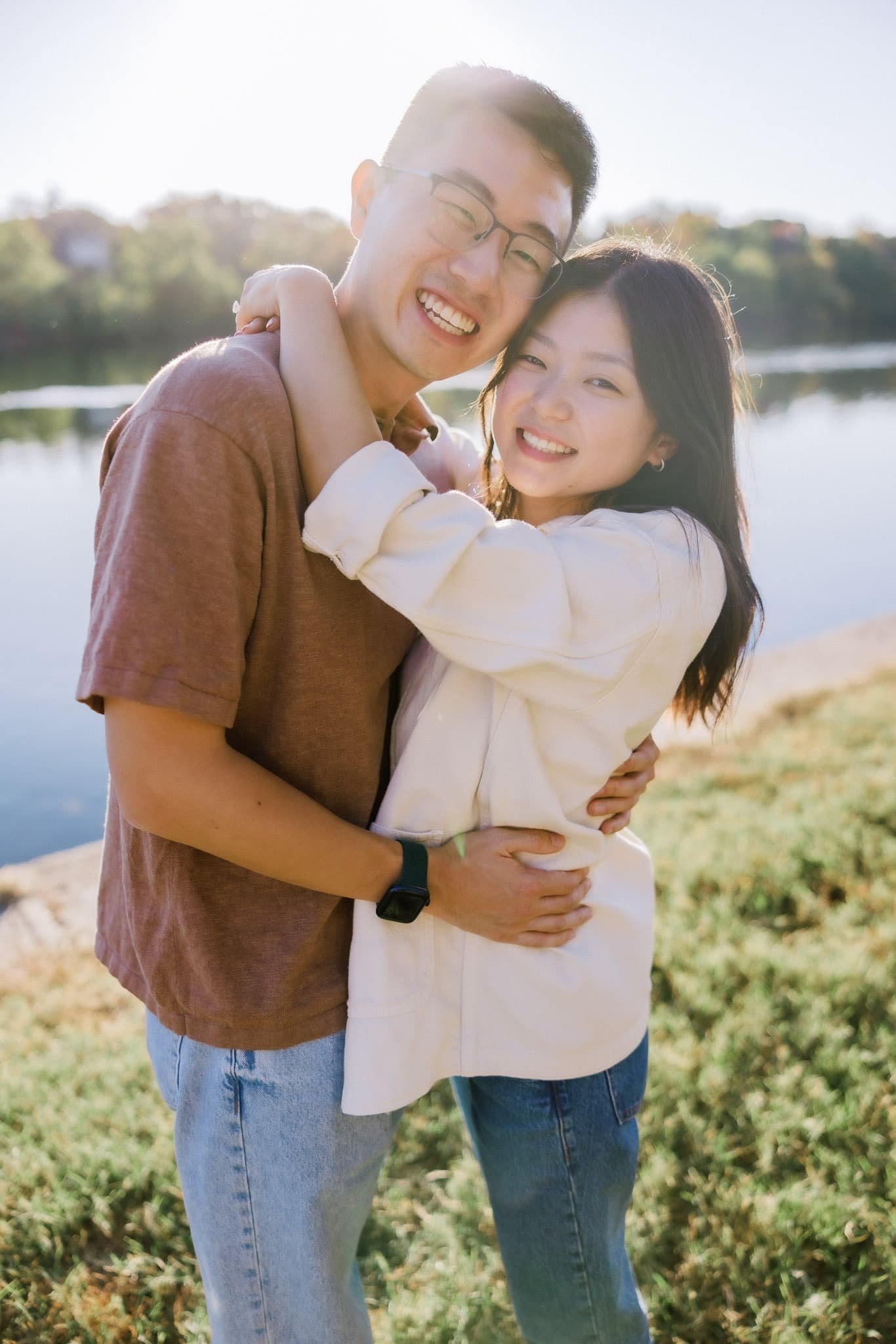 Couple laughing together on a bright afternoon by the lake