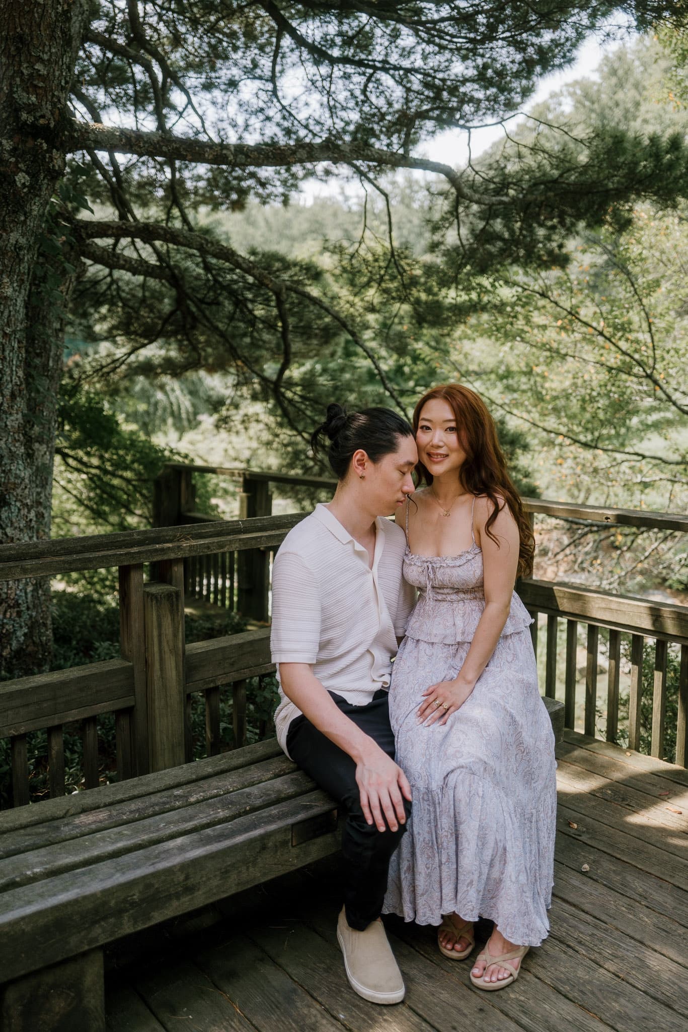 Couple sitting close on a wooden bench in a Japanese garden