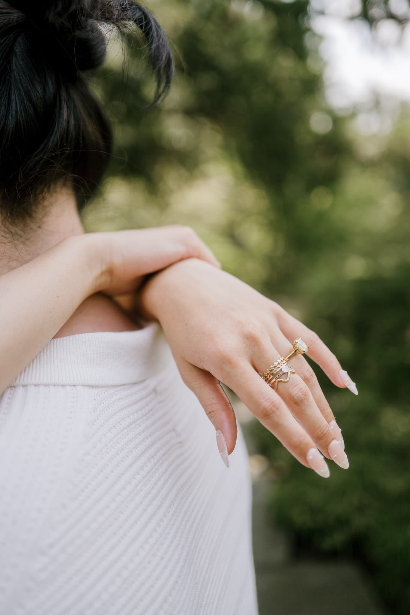 Engagement ring on a hand wrapped over a shoulder