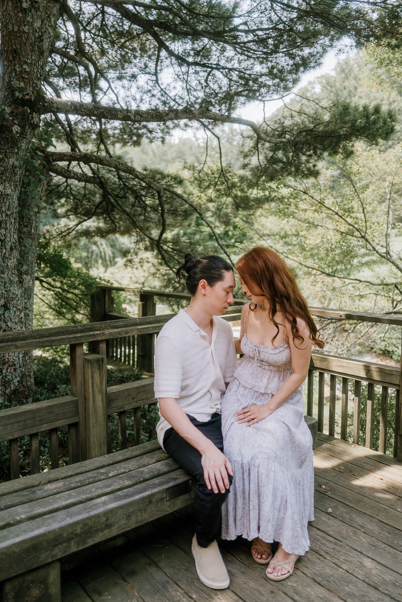 Couple sitting together on a garden bench beneath the trees