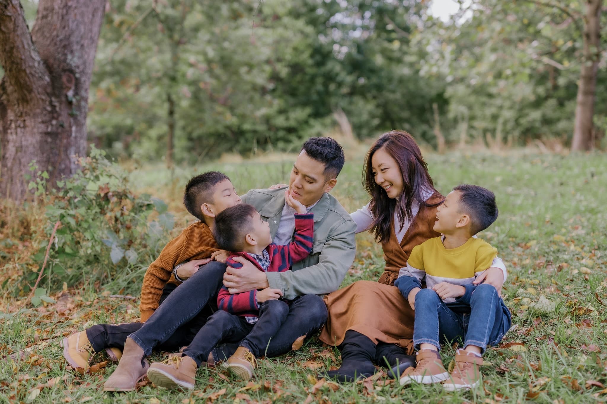 Family laughing together on the grass in the park