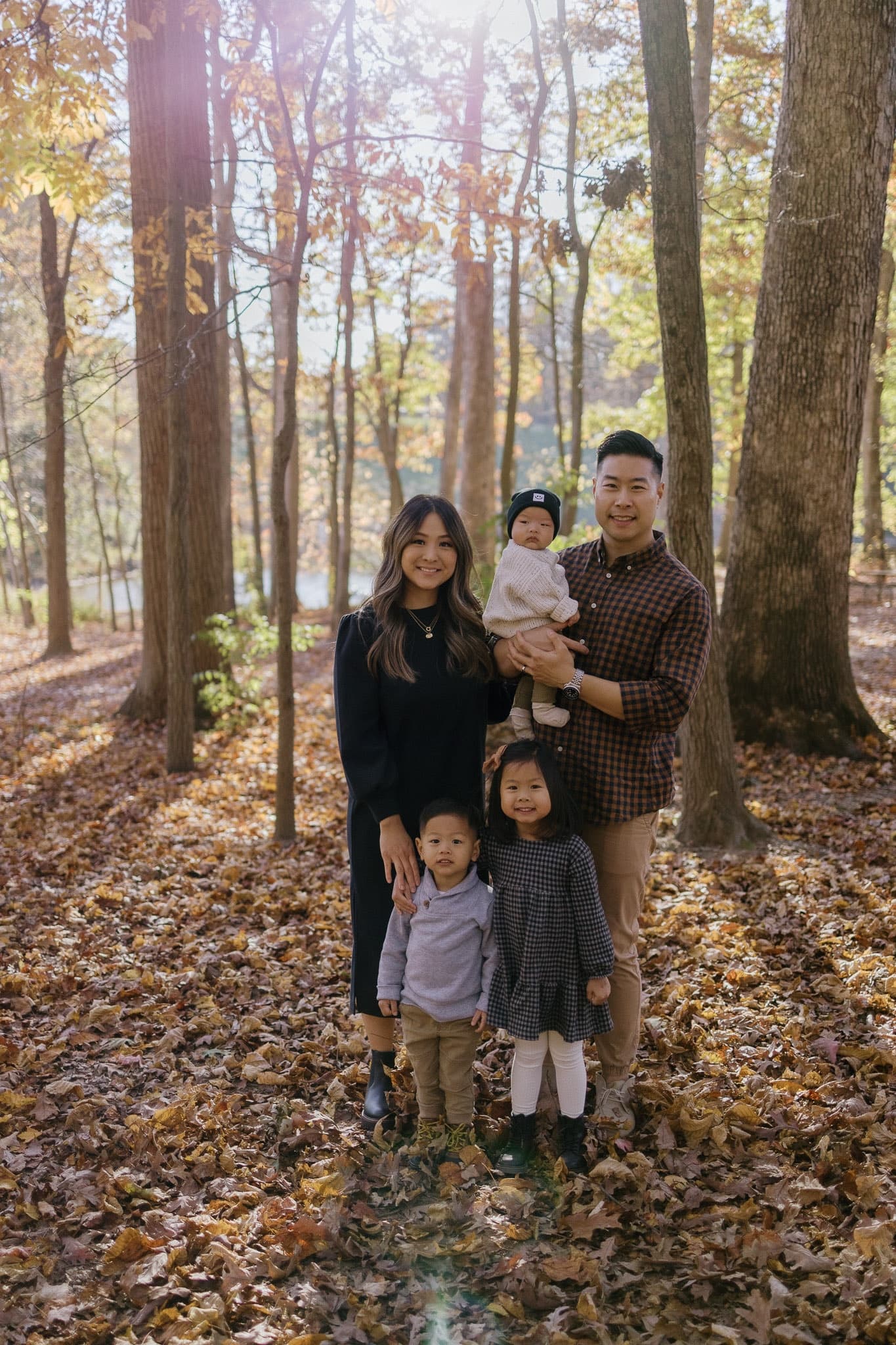 Family of five standing together in the autumn woods