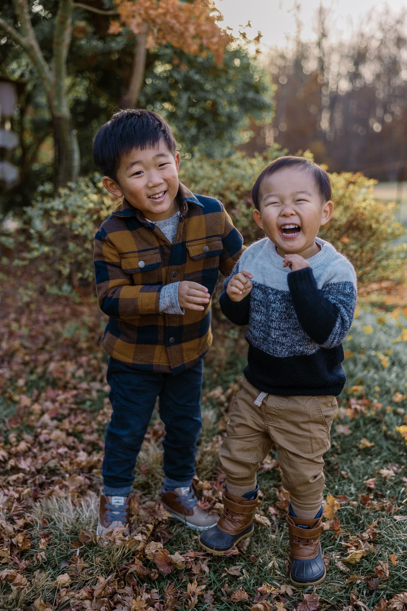 Two young children laughing together outdoors