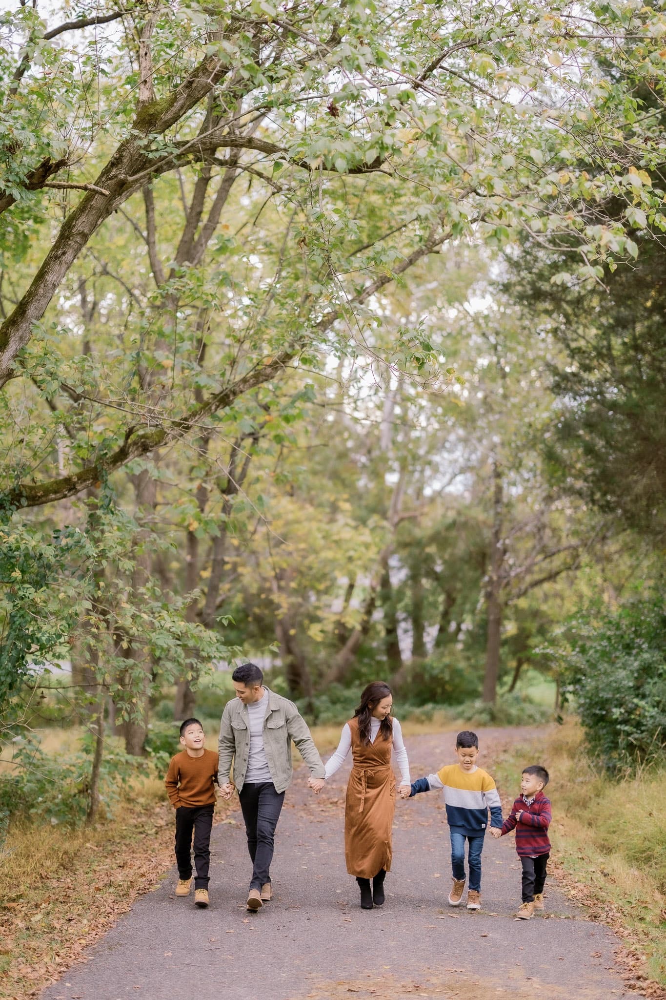 Family walking down a tree-lined path