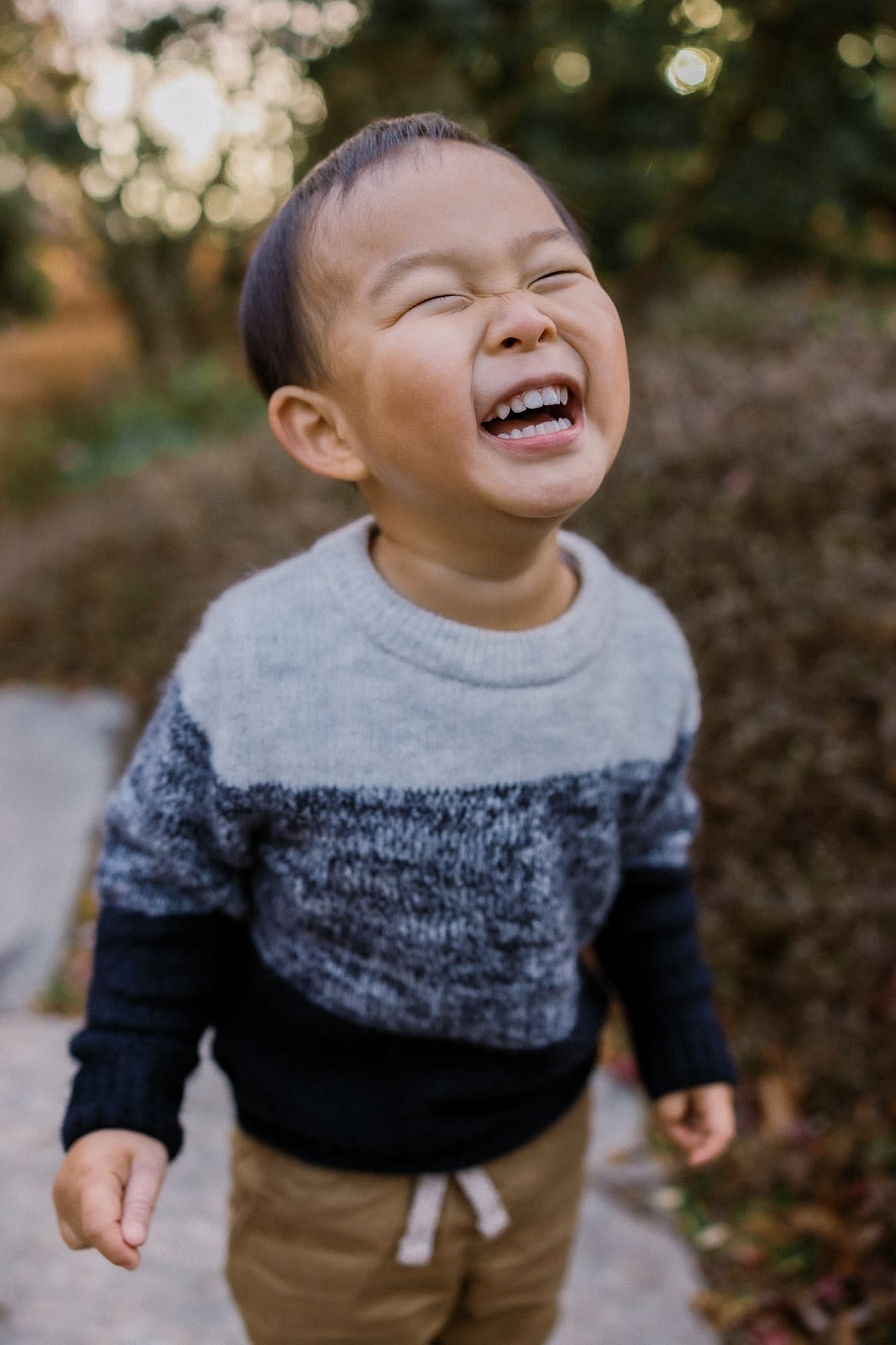 Toddler laughing with eyes squeezed shut