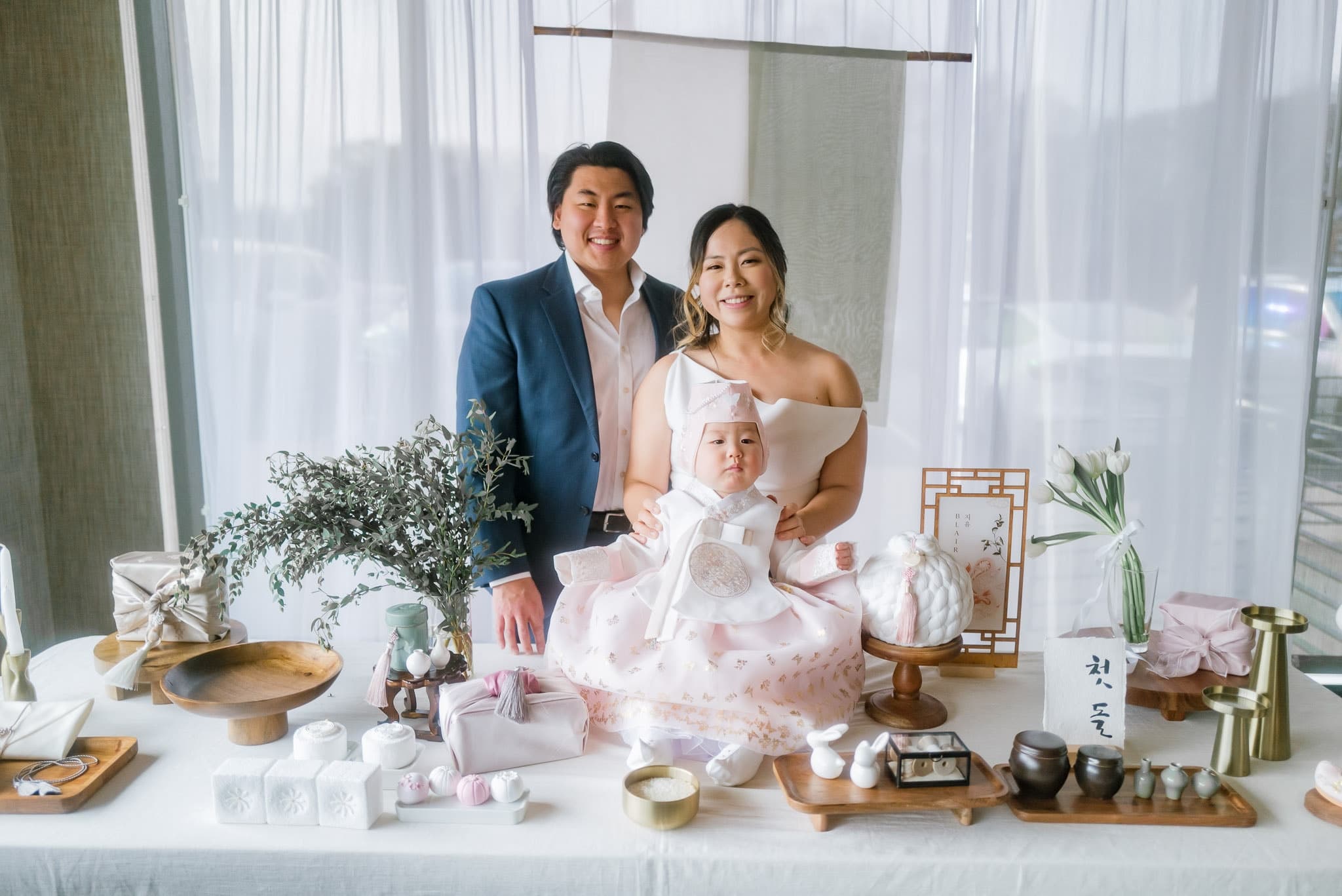 Parents and baby in hanbok at the decorated table