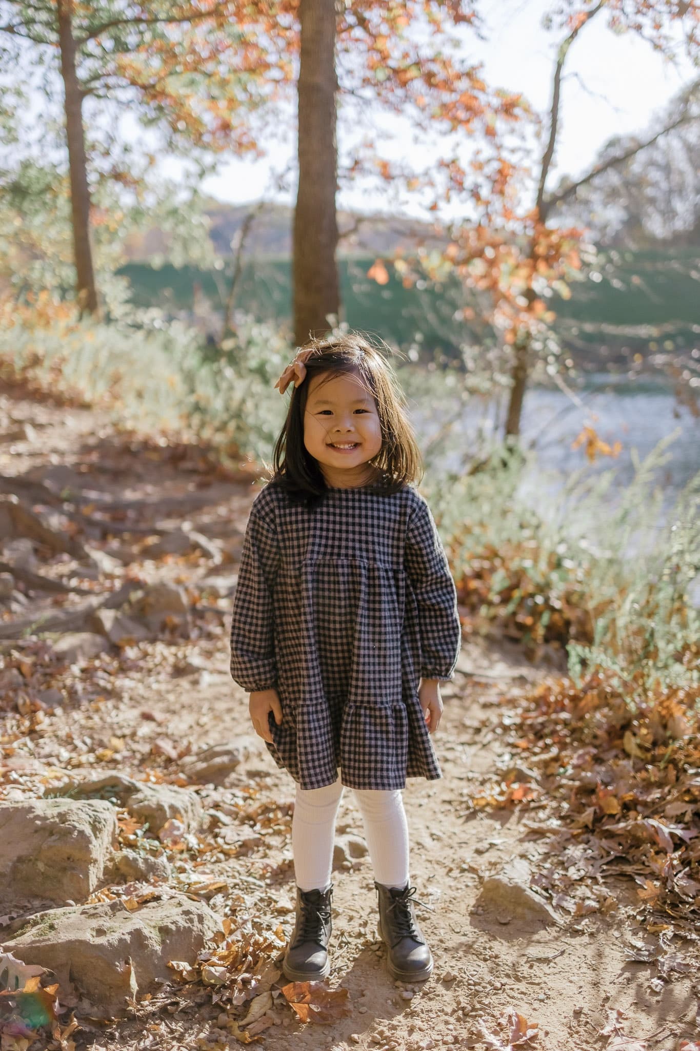 Little one standing on a leafy trail by the water