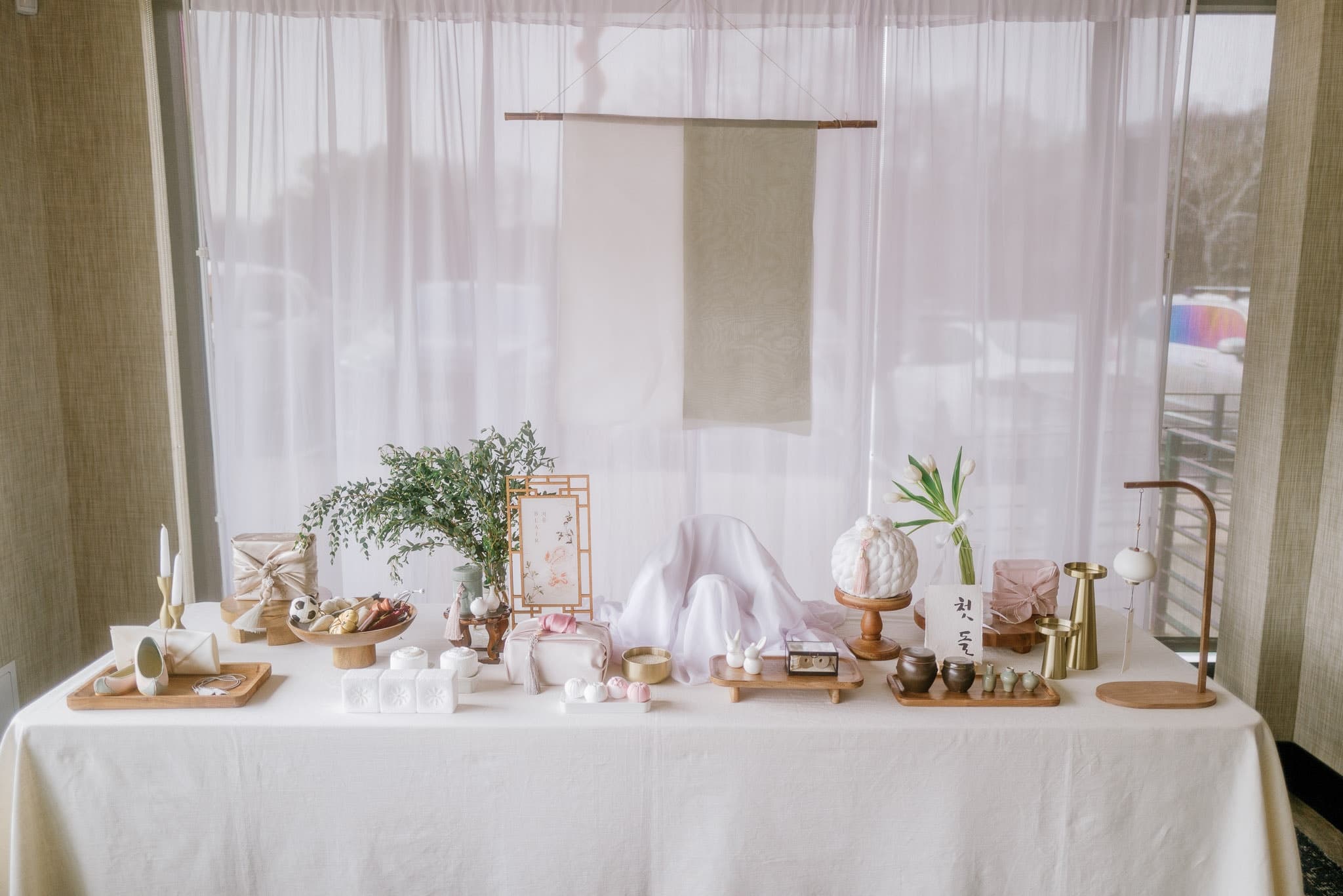 First-birthday table set against sheer white curtains