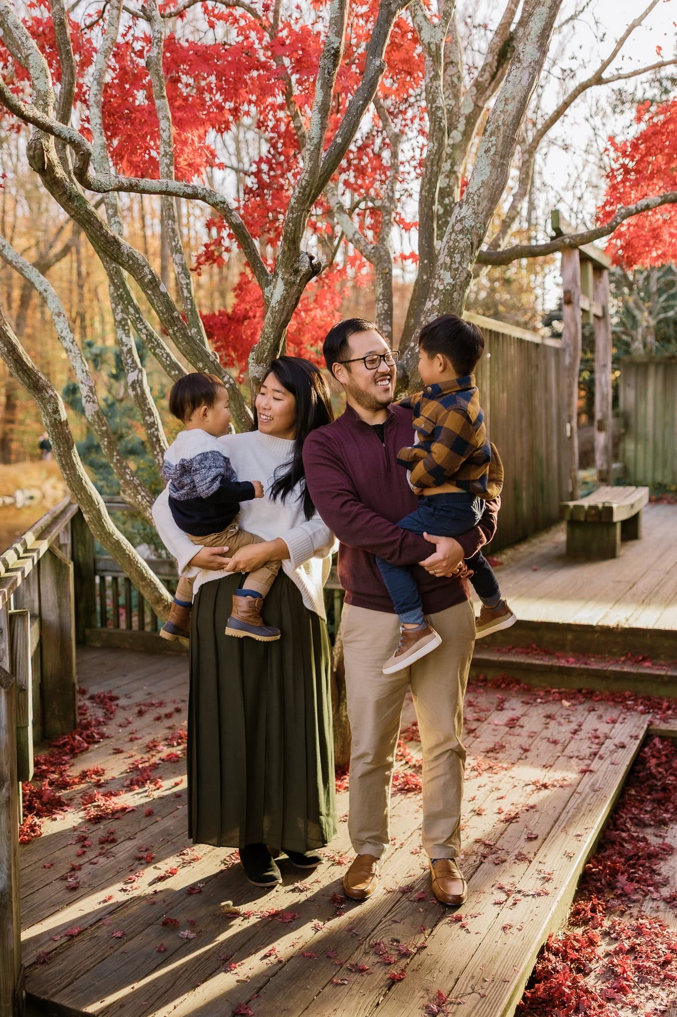 Family on a wooden deck beneath autumn branches