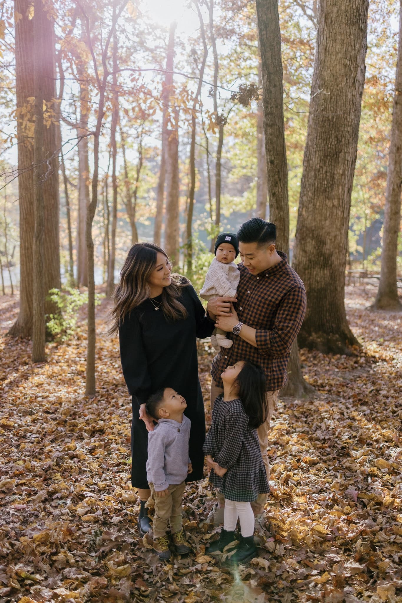 Family of five sharing a moment in the autumn woods