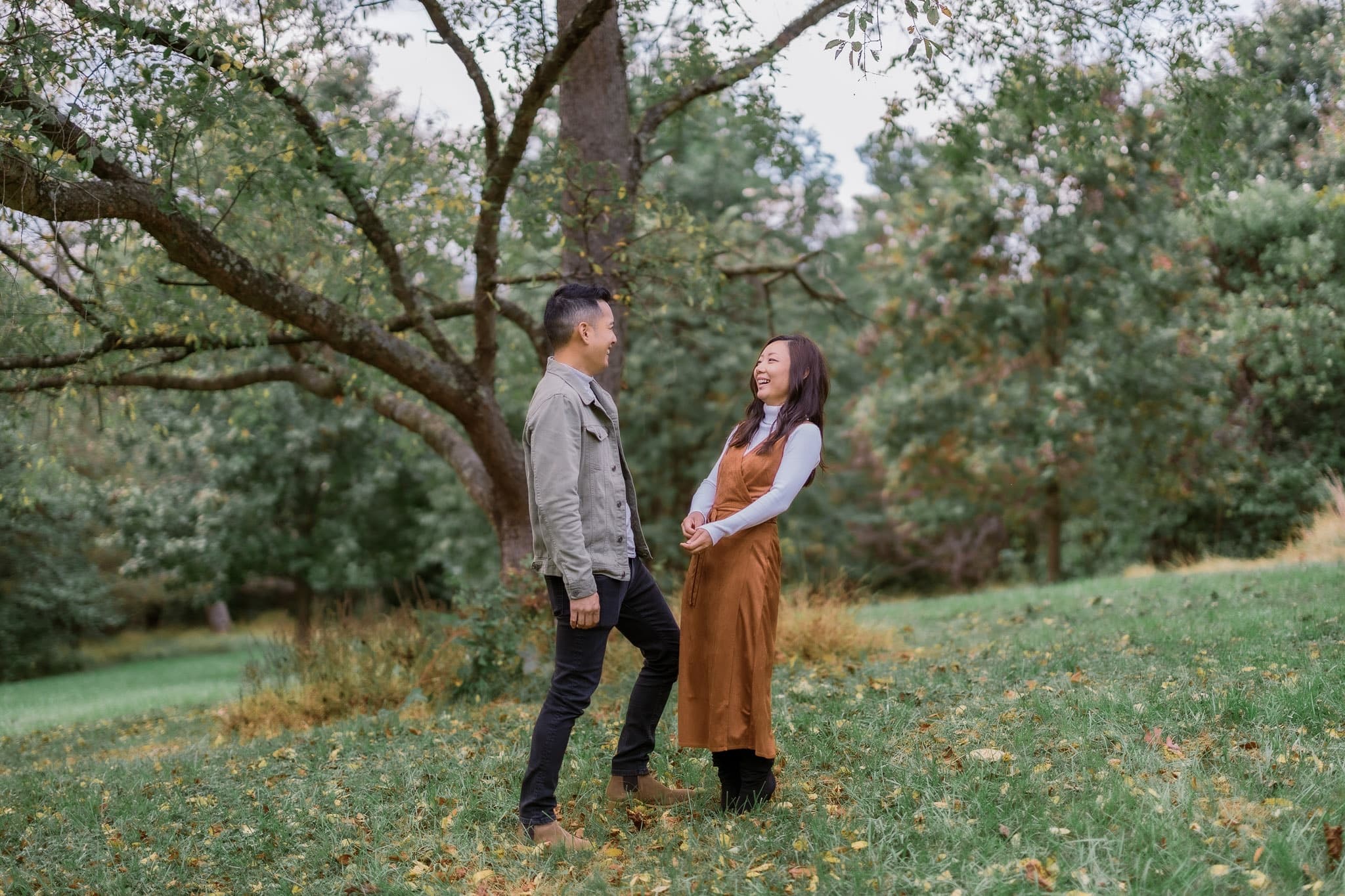 Couple smiling at each other under a spreading tree