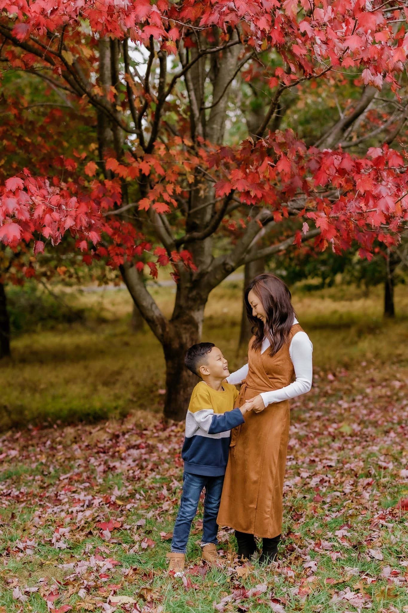 Parent and child beneath a red maple