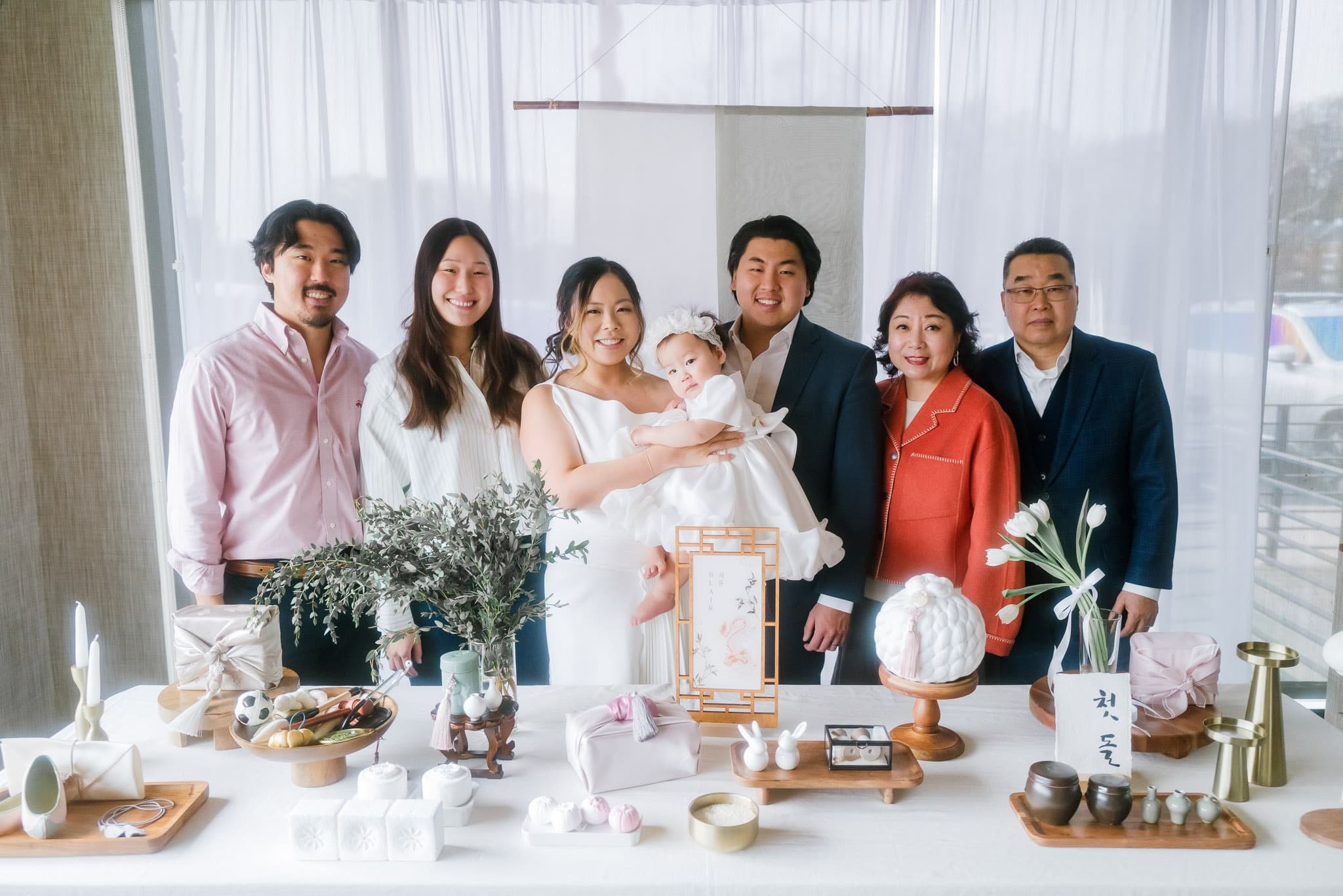 Extended family gathered around the first-birthday table