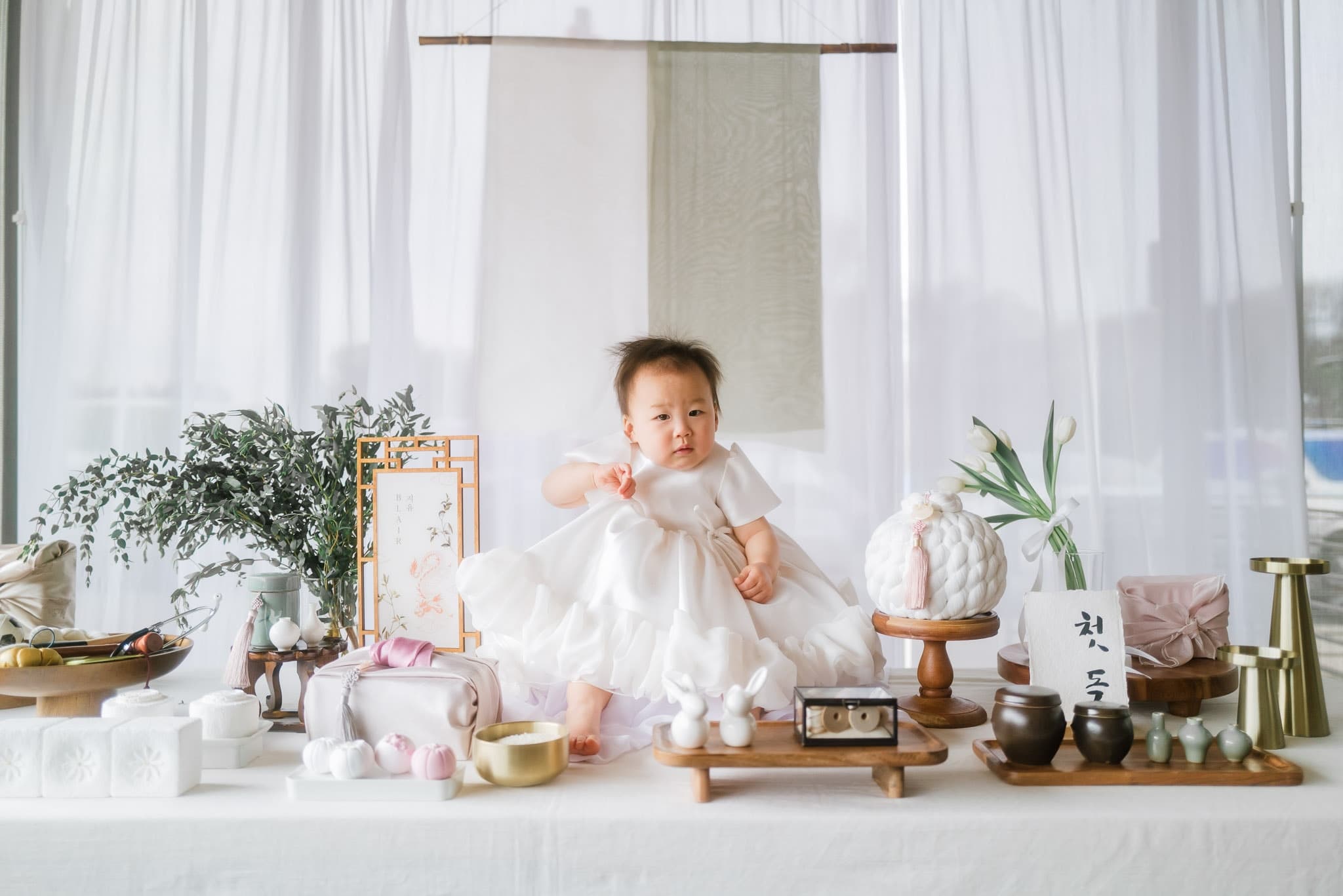 Baby sitting at the center of the first-birthday table