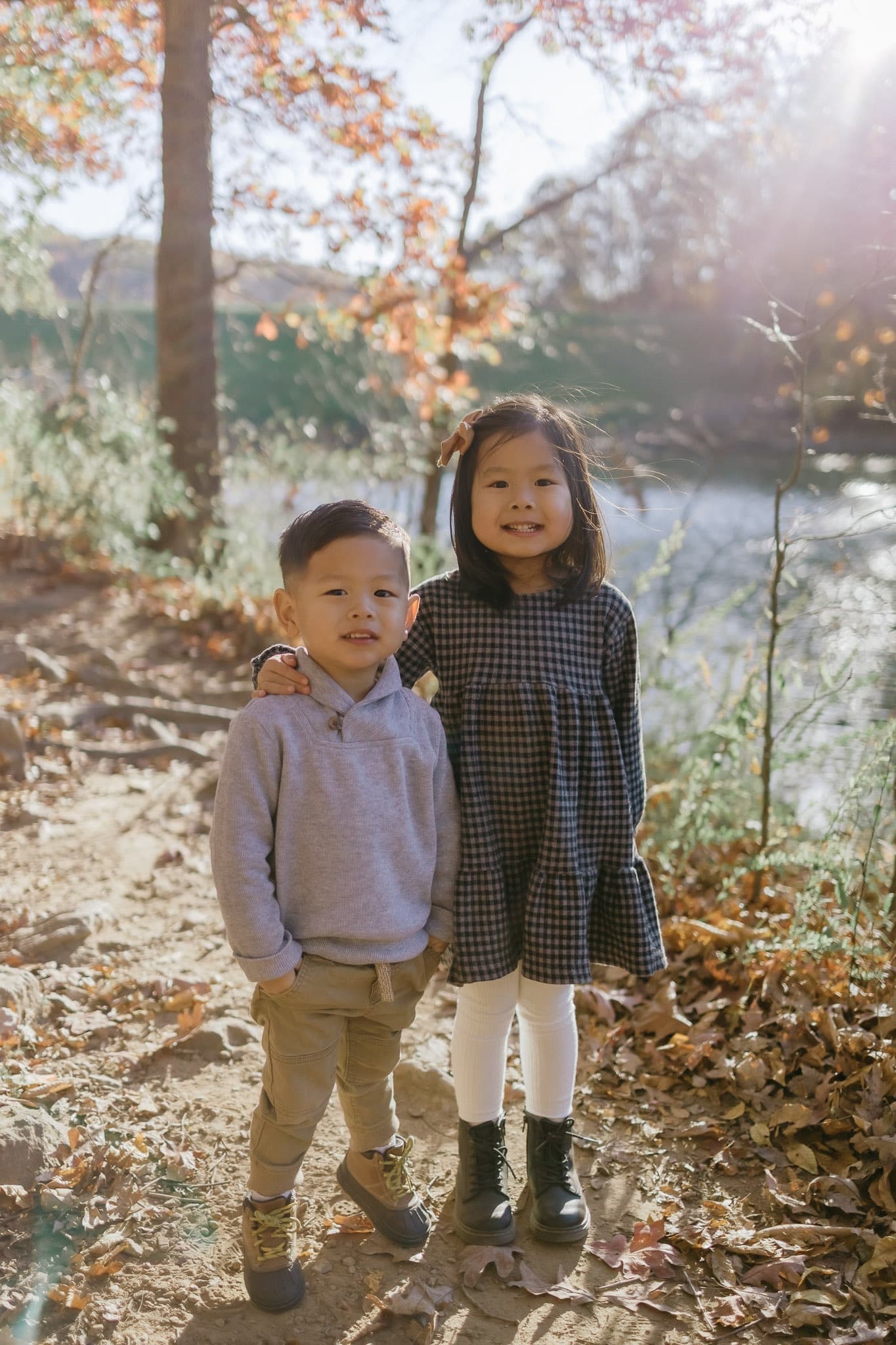 Two siblings standing by the water