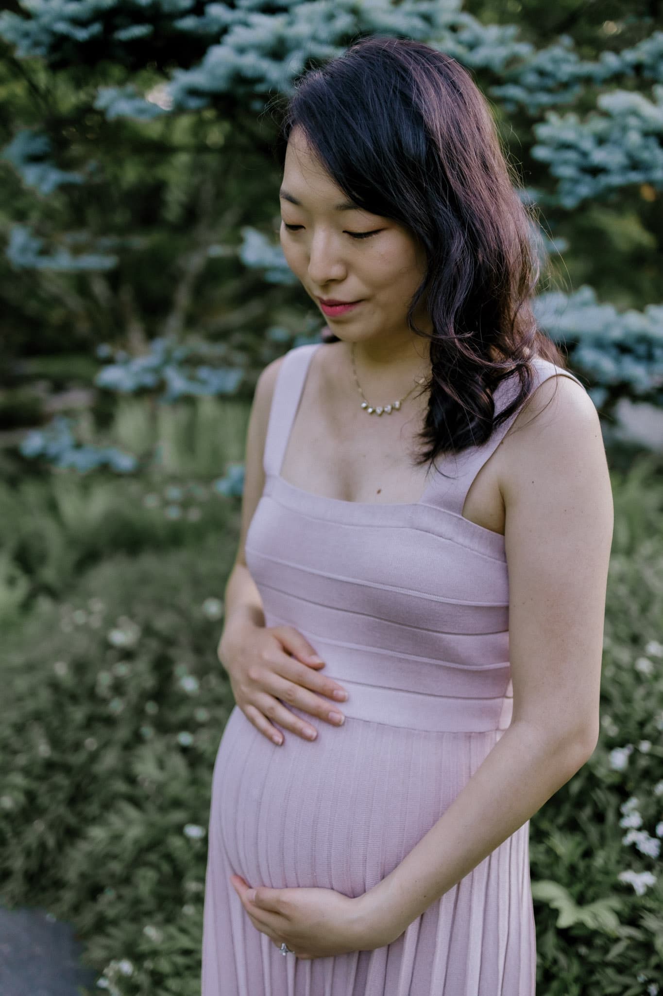Close portrait of hands resting on a baby bump
