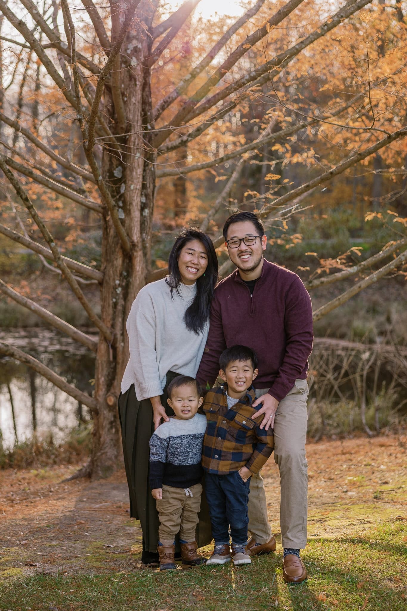 Family of four standing together in autumn
