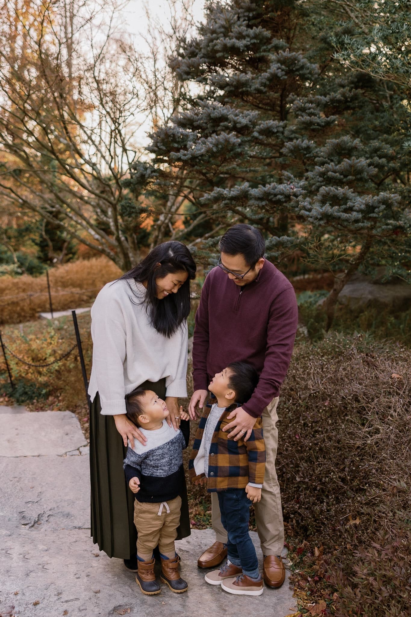 Family cuddled together on a garden path