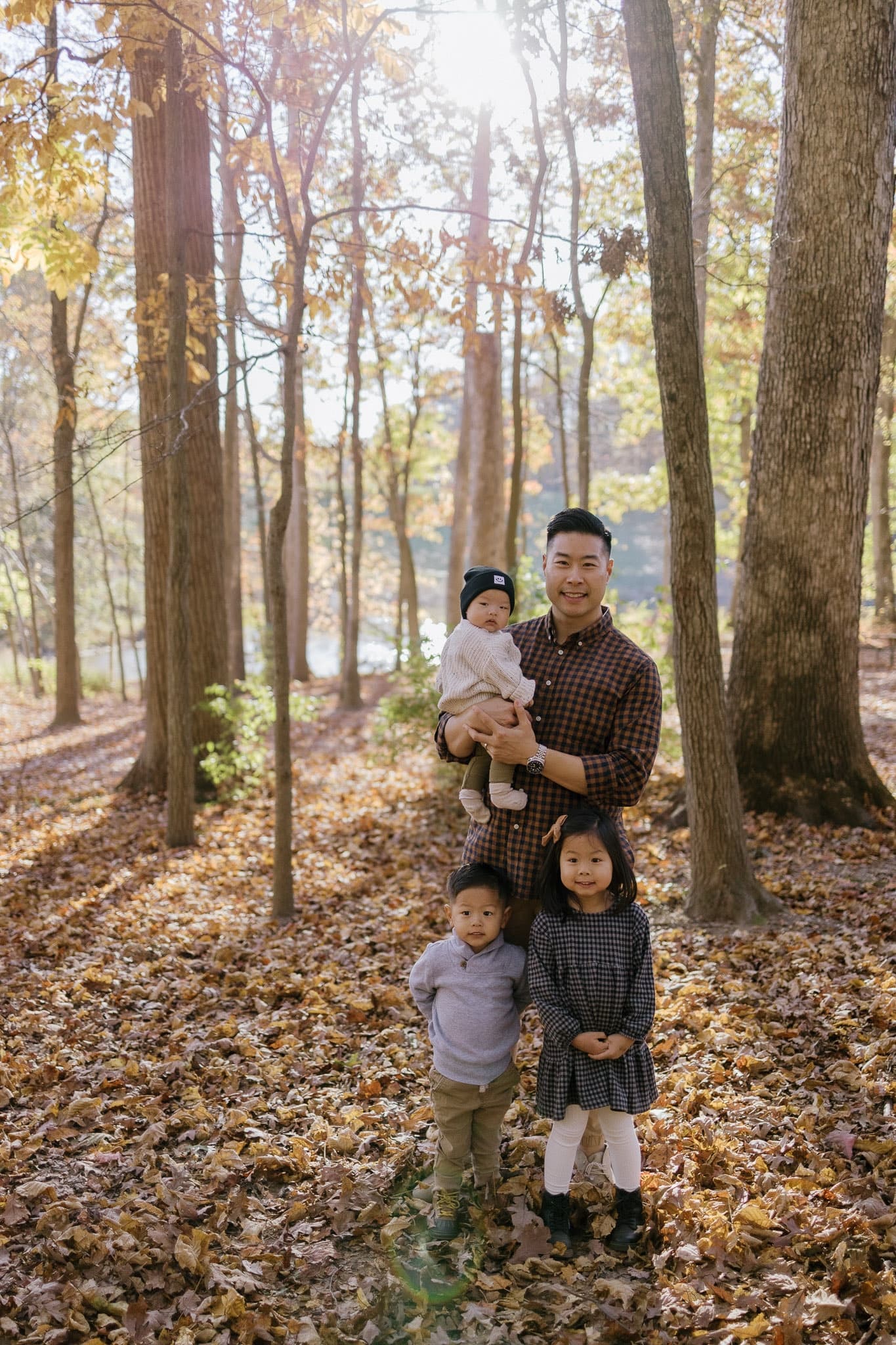 Family standing among tall autumn trees