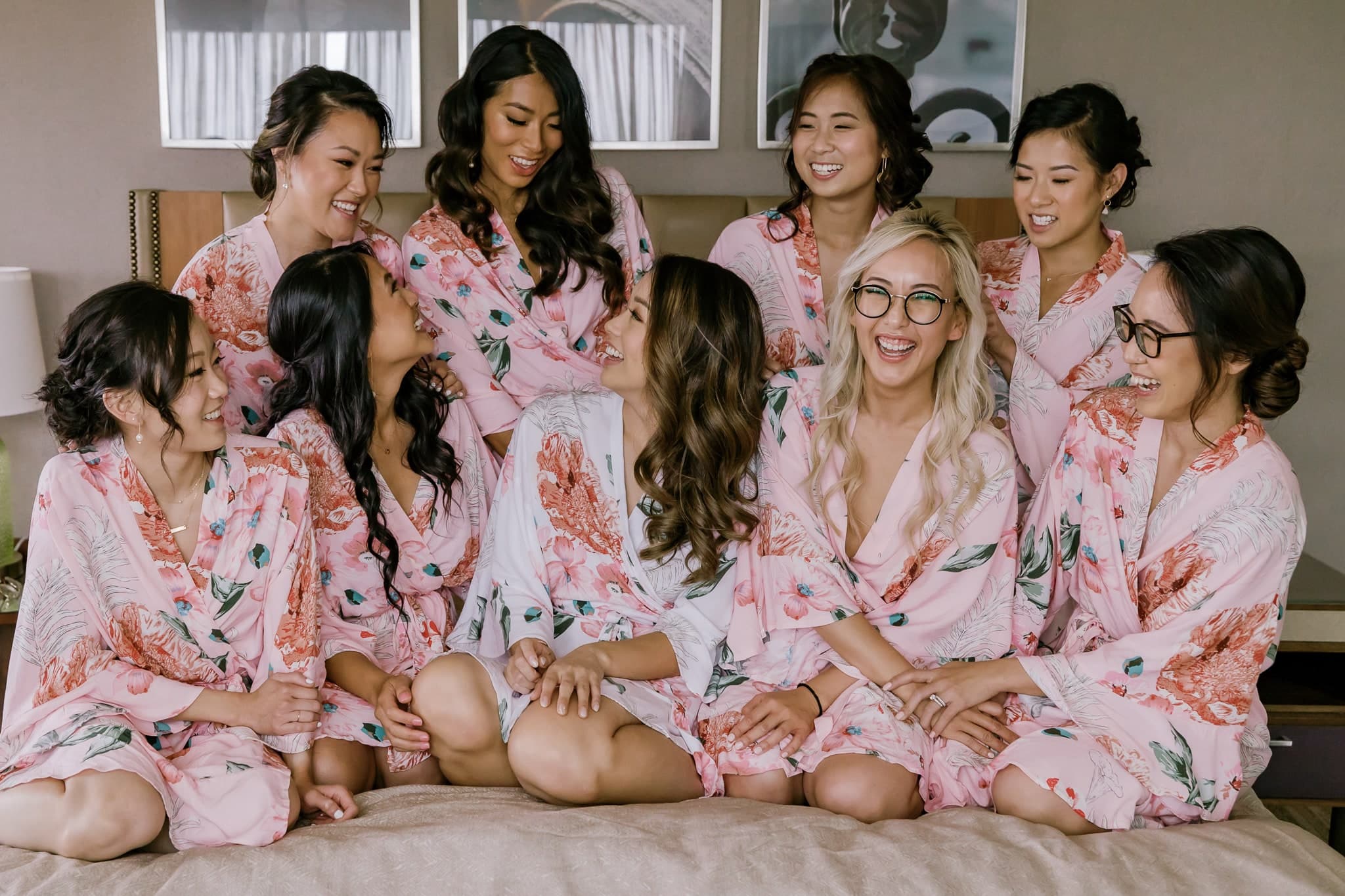 Bridesmaids in matching floral robes laughing together