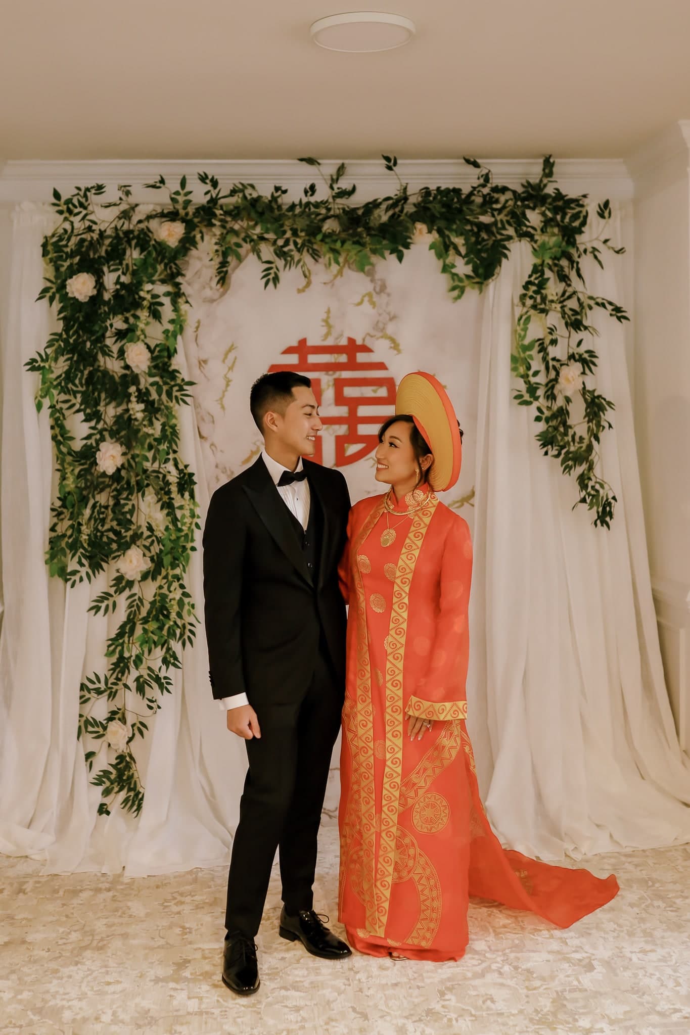 Bride in a red traditional dress beside the groom at the tea ceremony