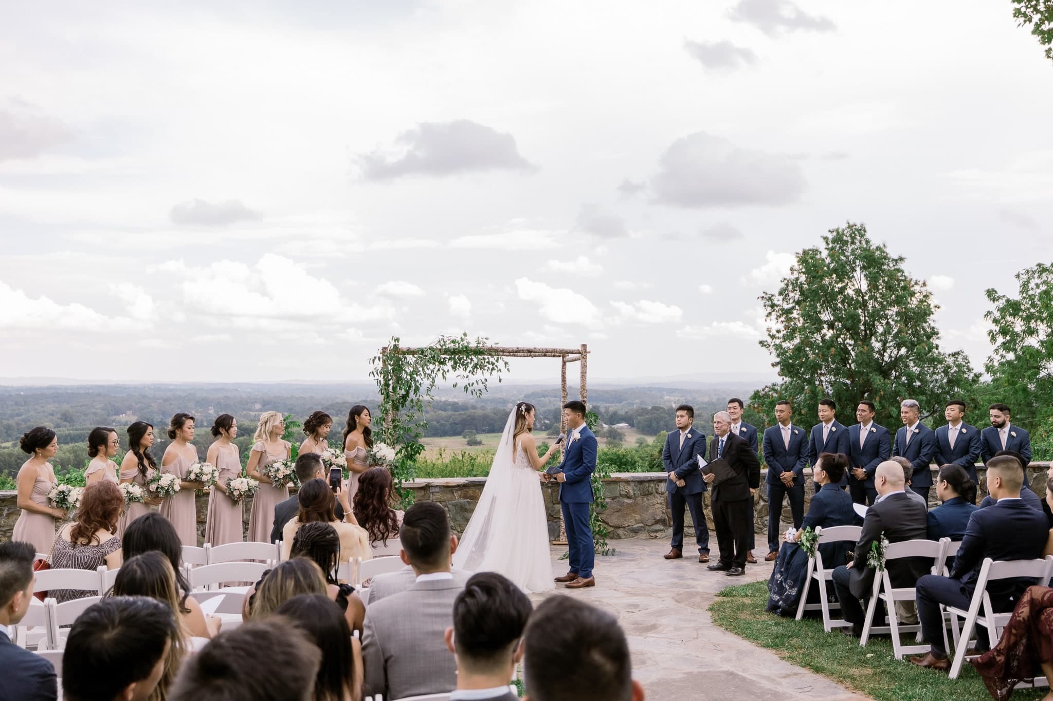 Ceremony at a hilltop arbor with views across the valley