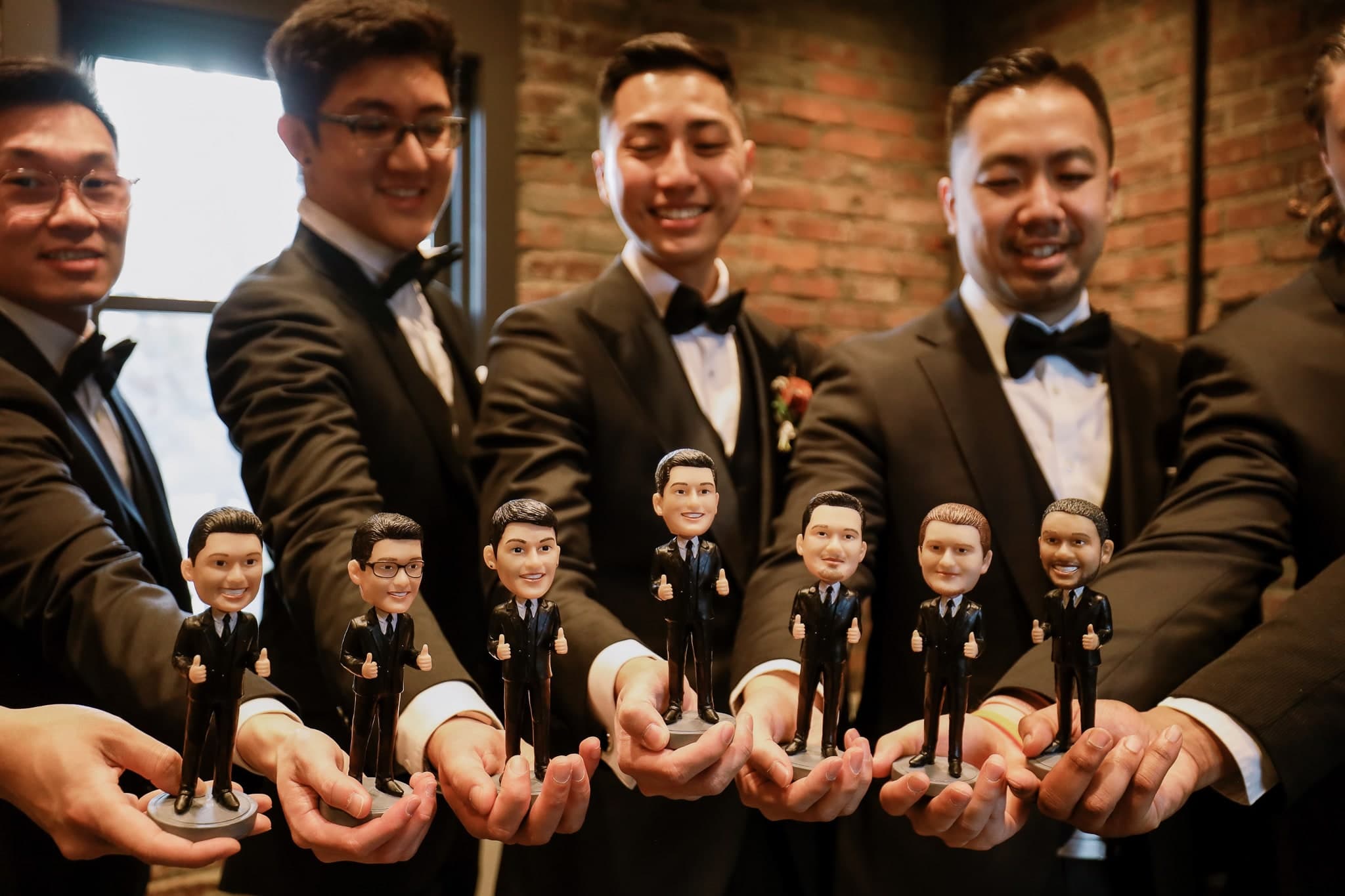 Groomsmen holding custom bobblehead figurines