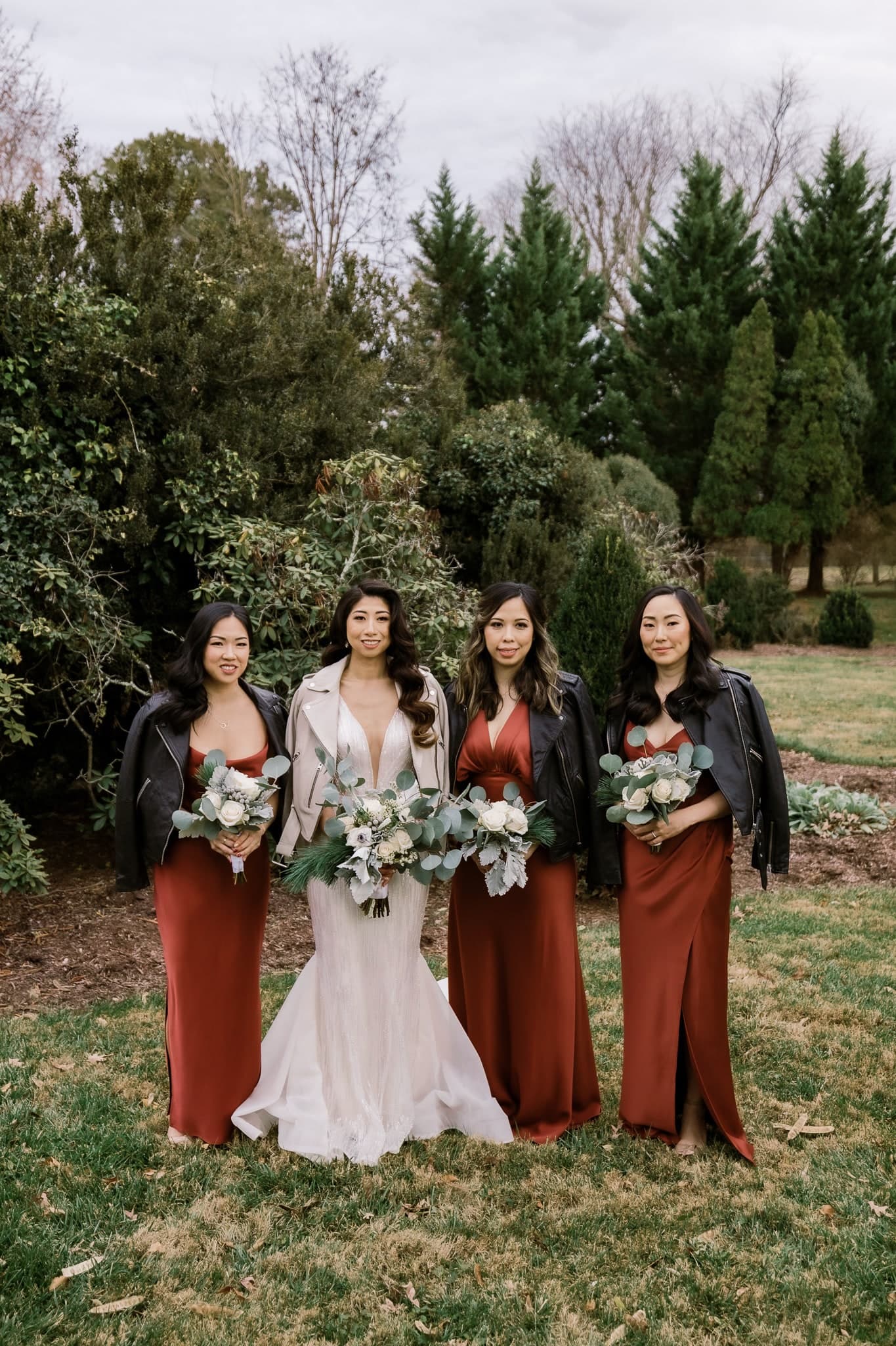 Bride with bridesmaids in rust gowns and leather jackets