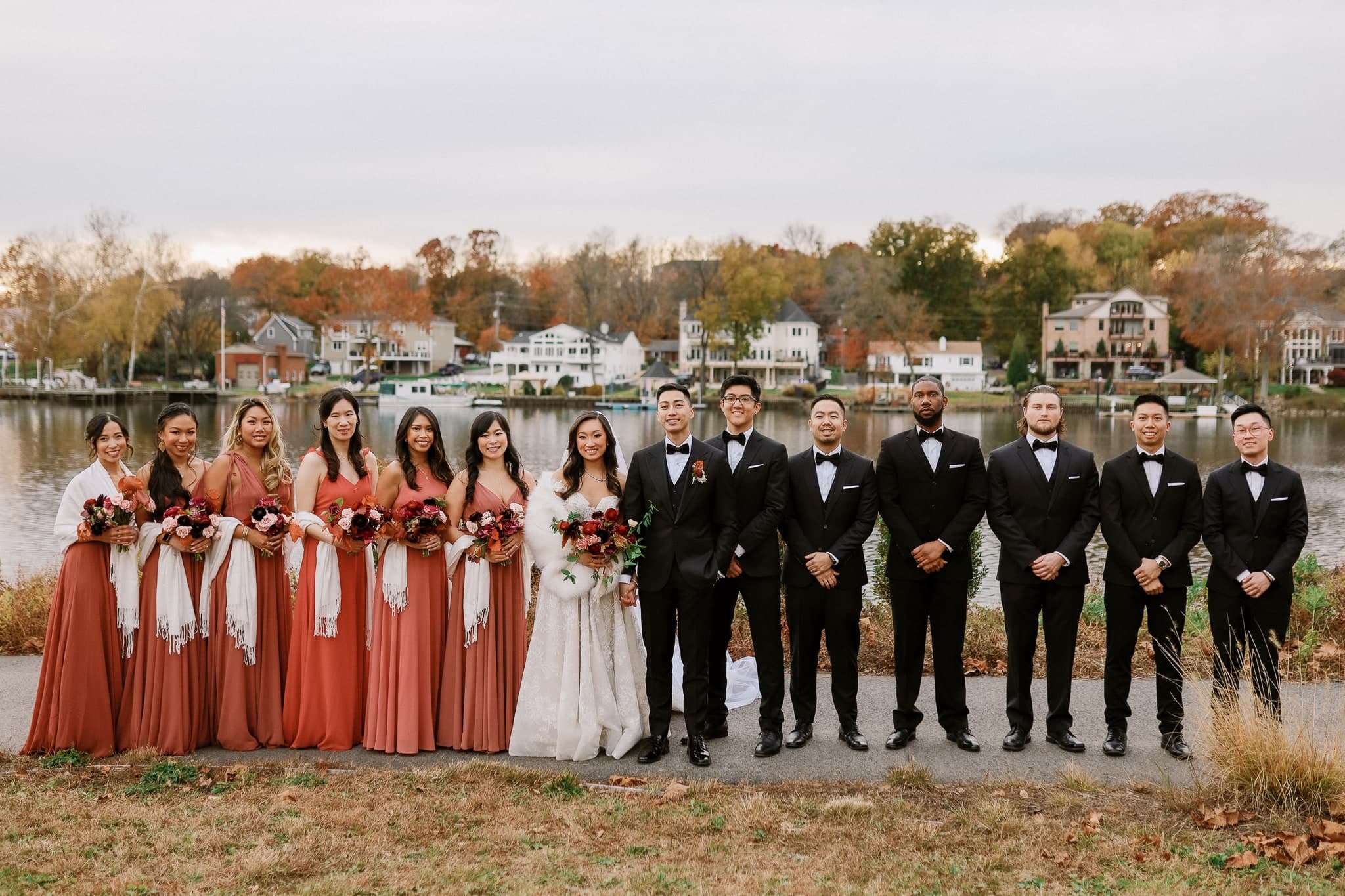 Wedding party lined up along the lake