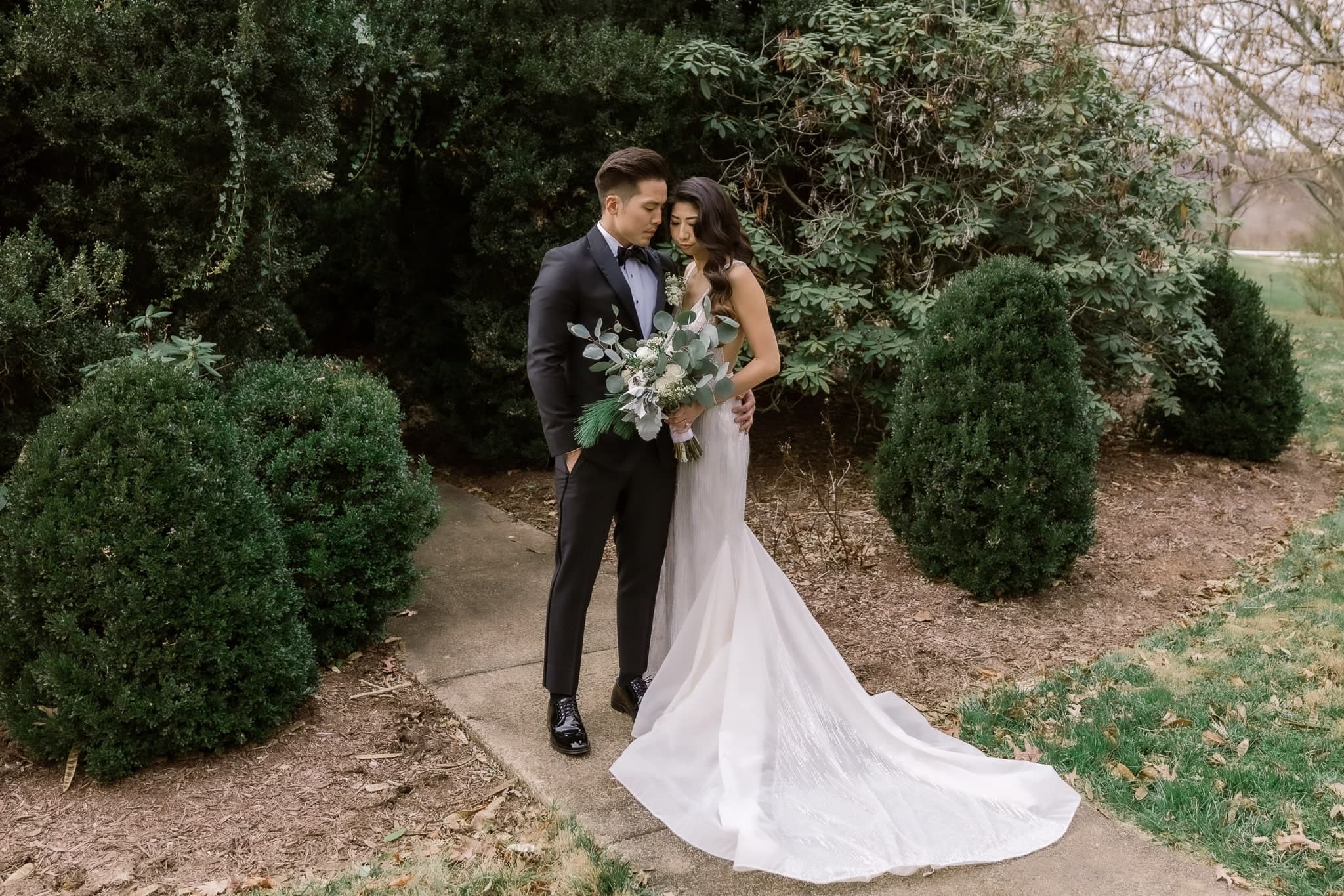 Couple framed by evergreen shrubs in the garden