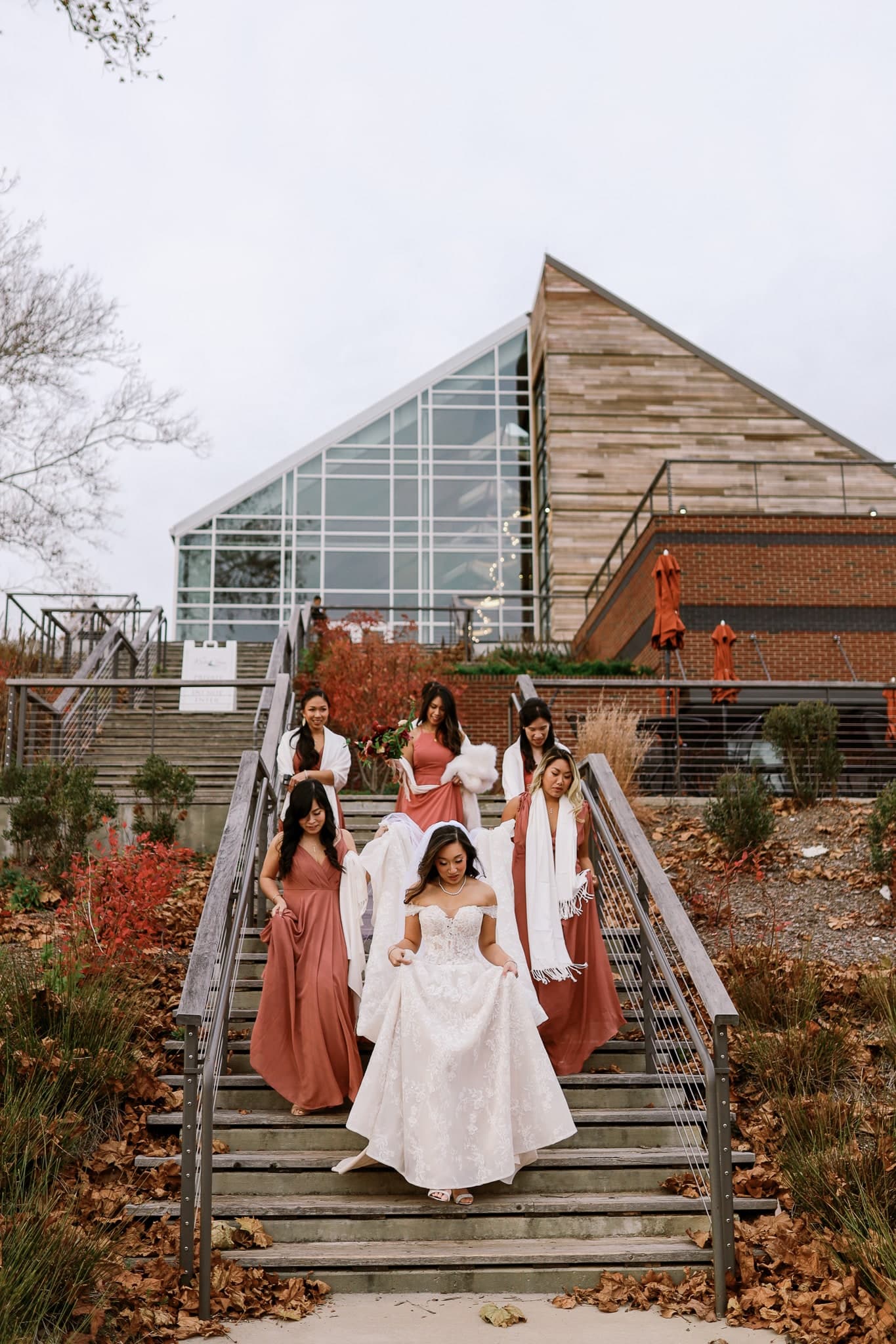 Bride descending the stairs with her bridesmaids