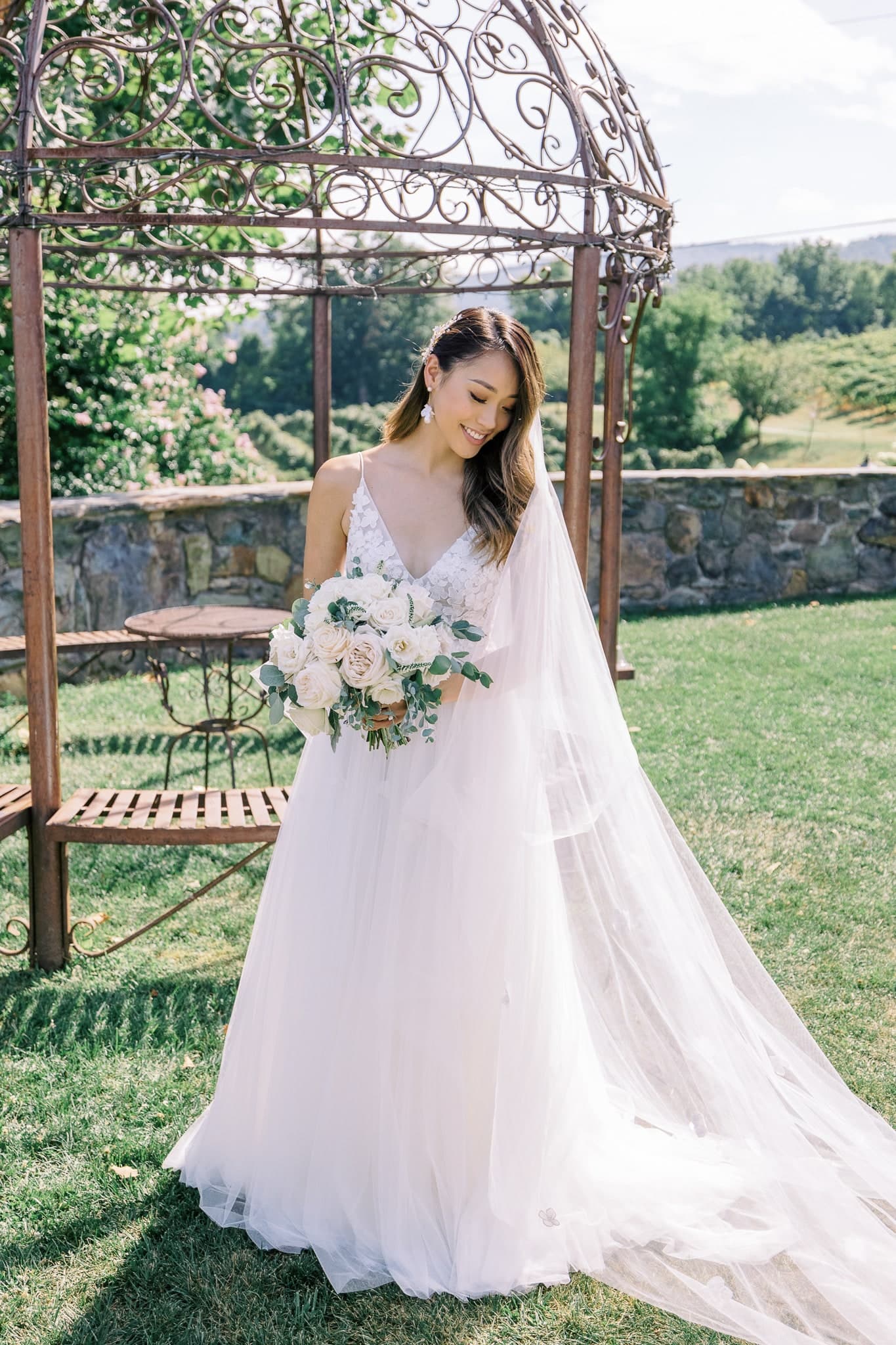 Bride beside an iron gazebo in the garden