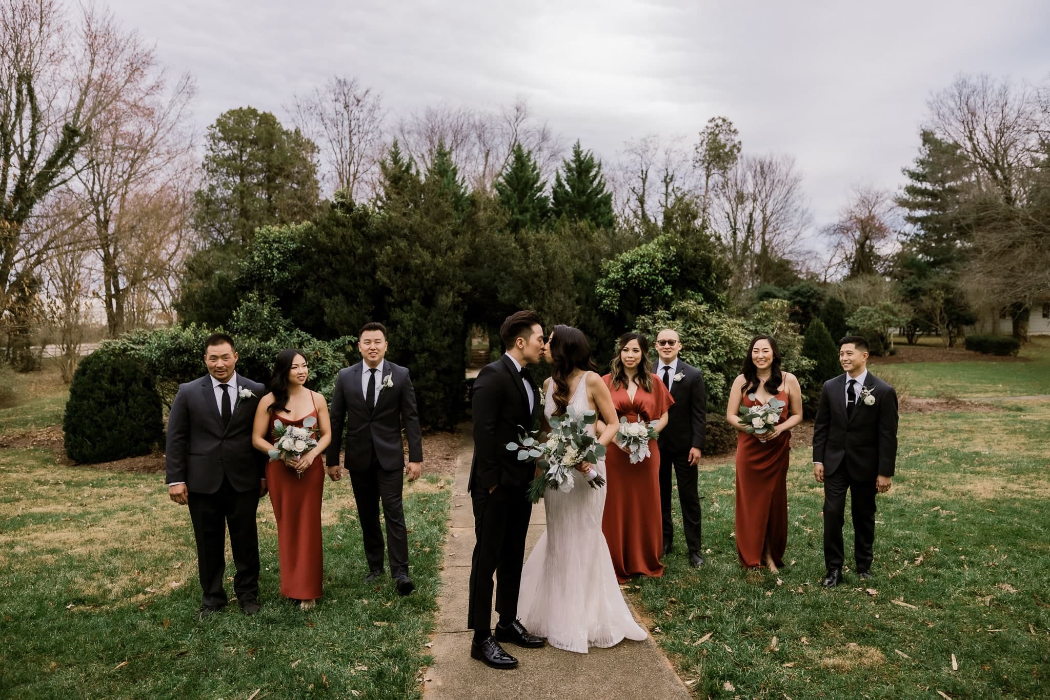Wedding party laughing as they walk the garden path