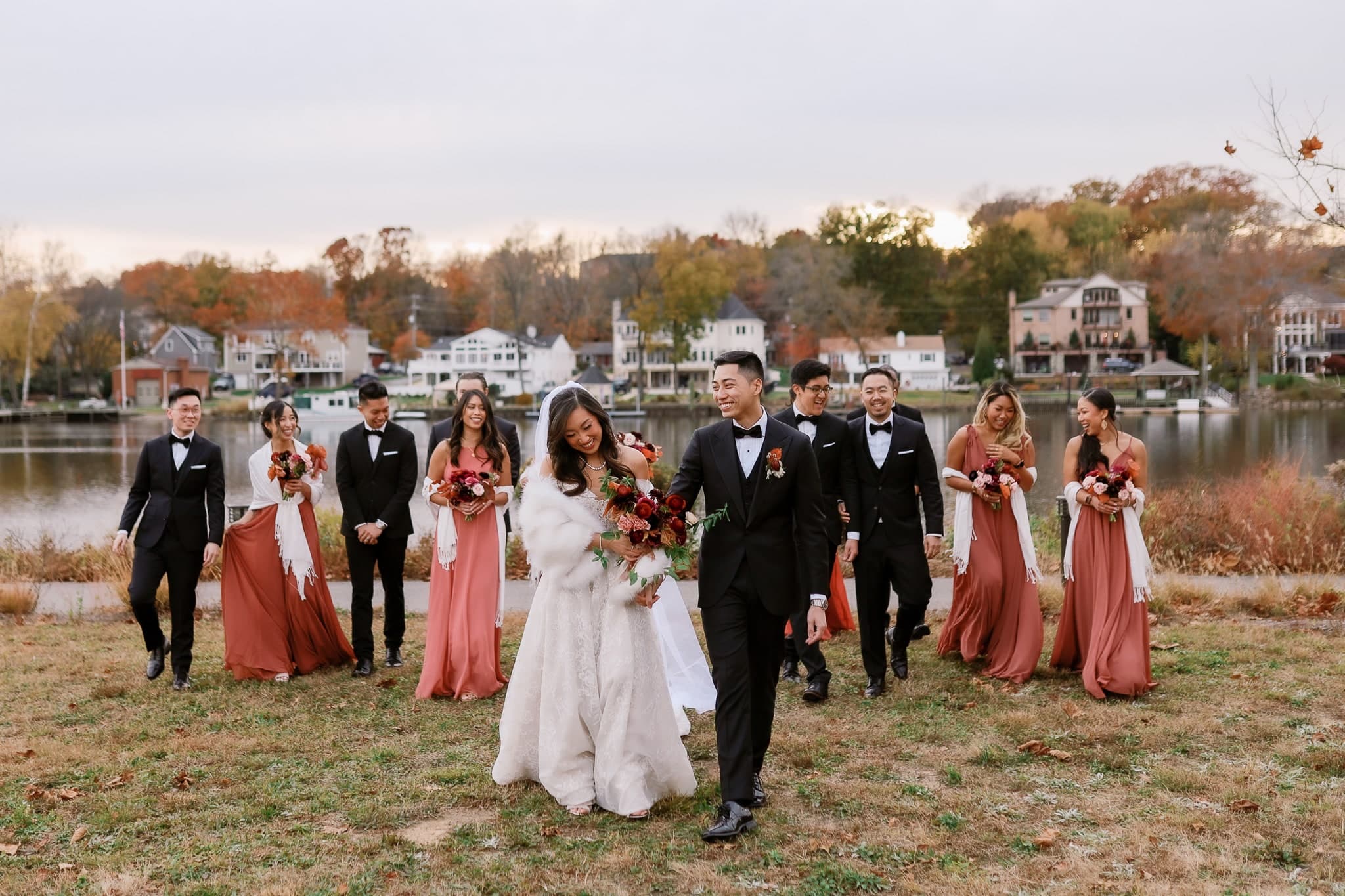 Couple leading the wedding party along the lake