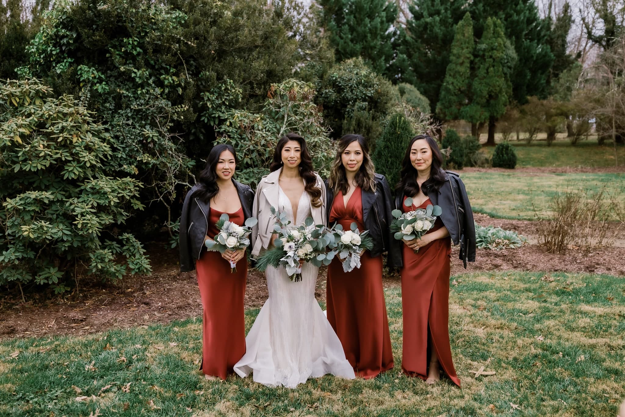 Bride with bridesmaids in rust gowns in the garden