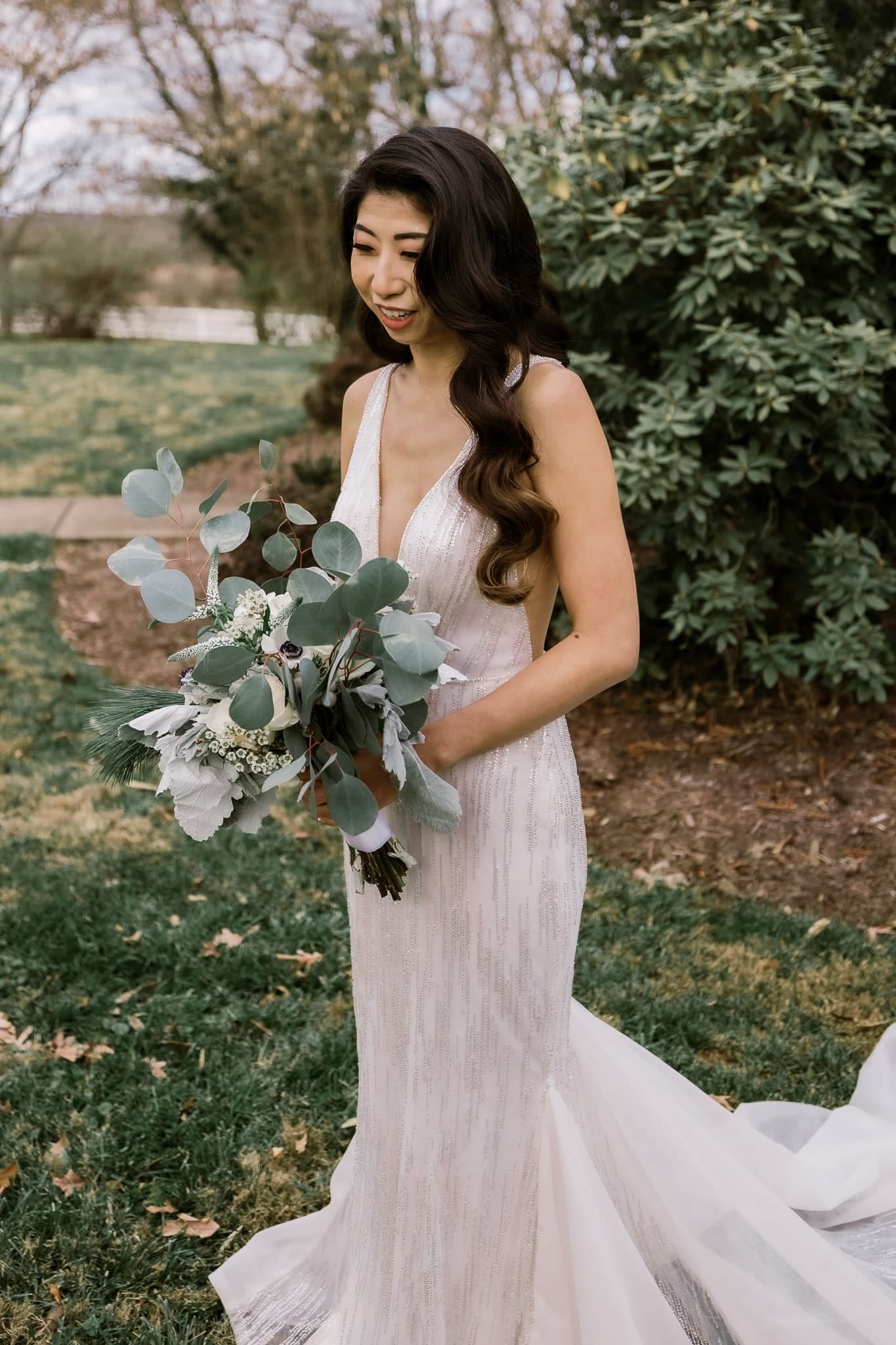 Bride smiling down at her bouquet