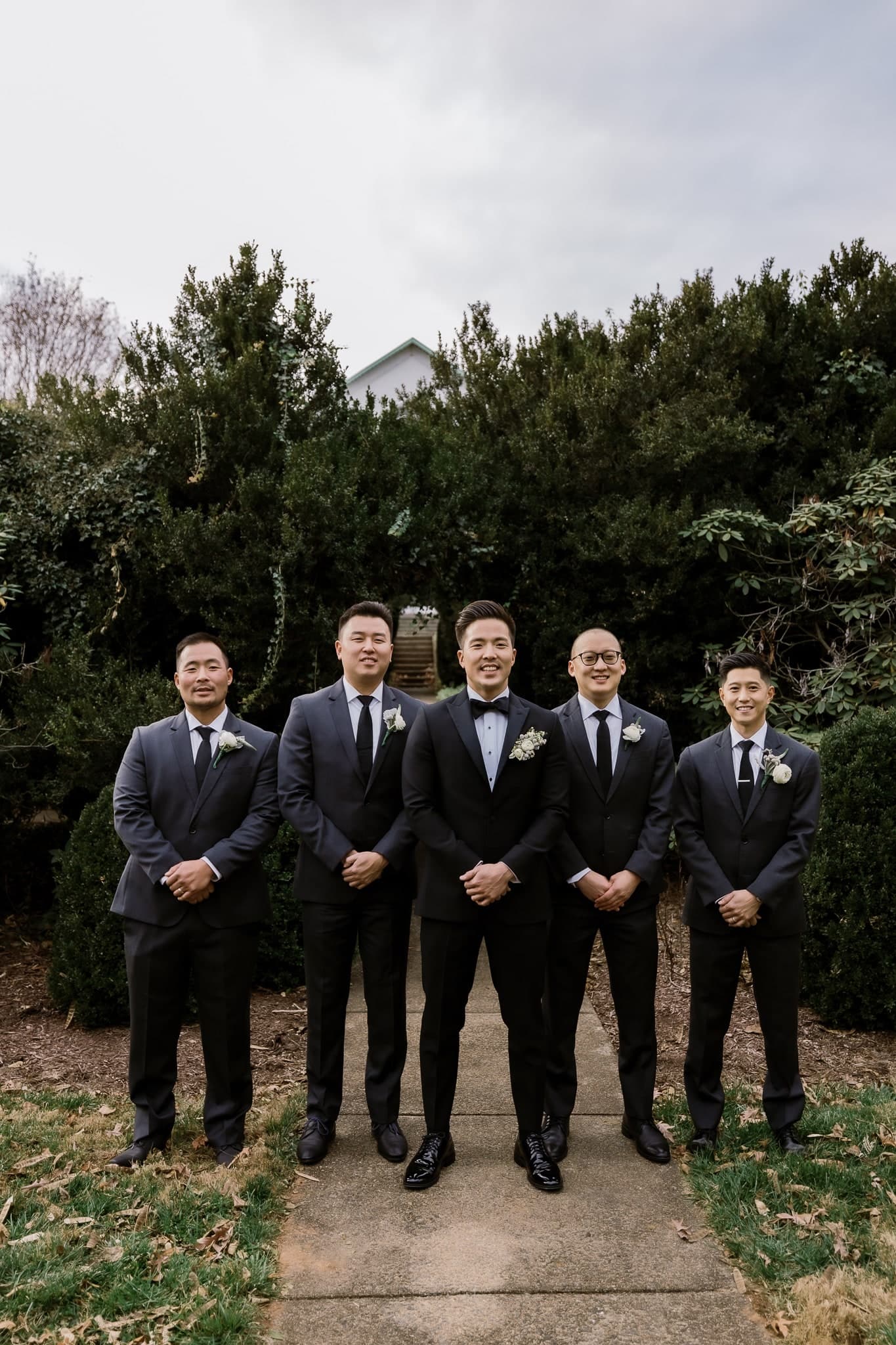 Groomsmen standing on the garden path