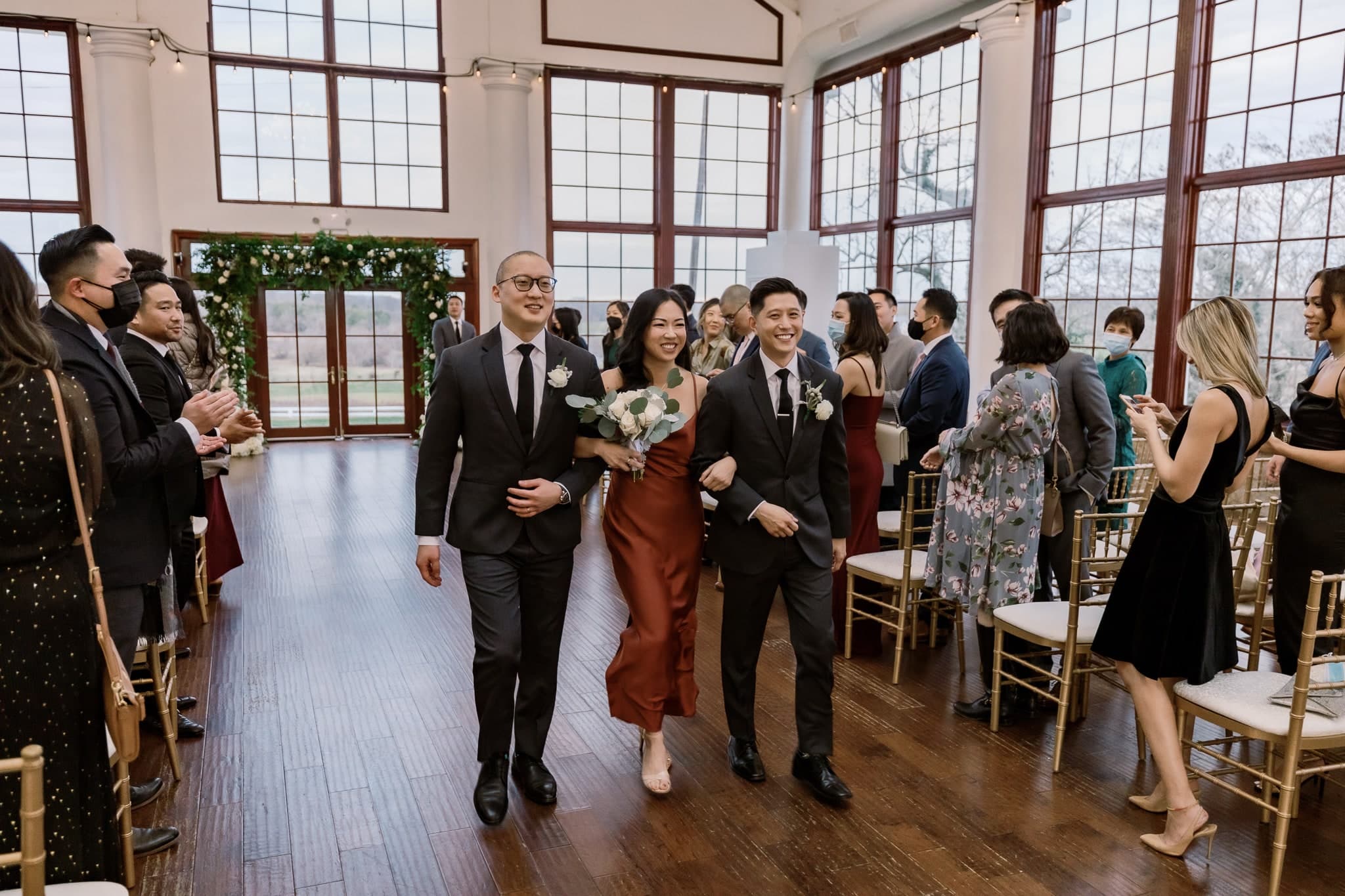 Wedding party recessional through cheering guests