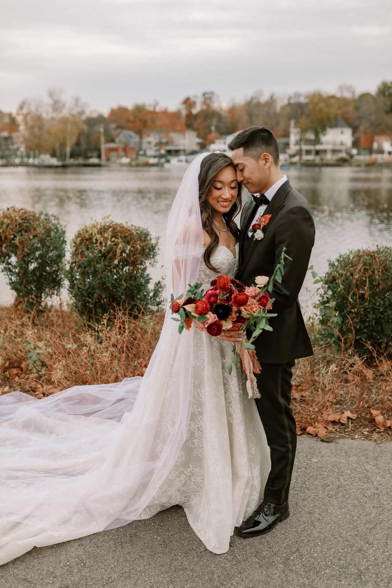 Couple leaning in close beside the lakeside hedges