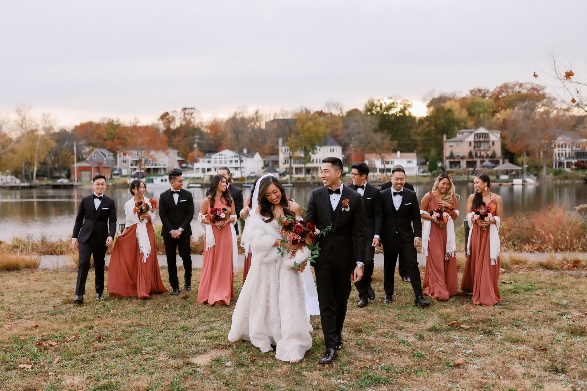 Couple walking with the wedding party along the shore