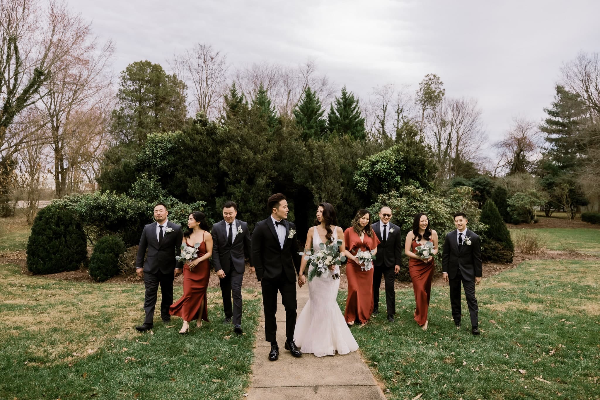 Wedding party walking together down the garden path