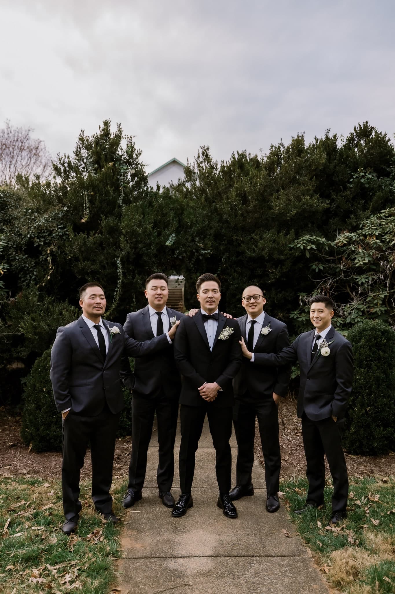Groomsmen lined up on the garden path