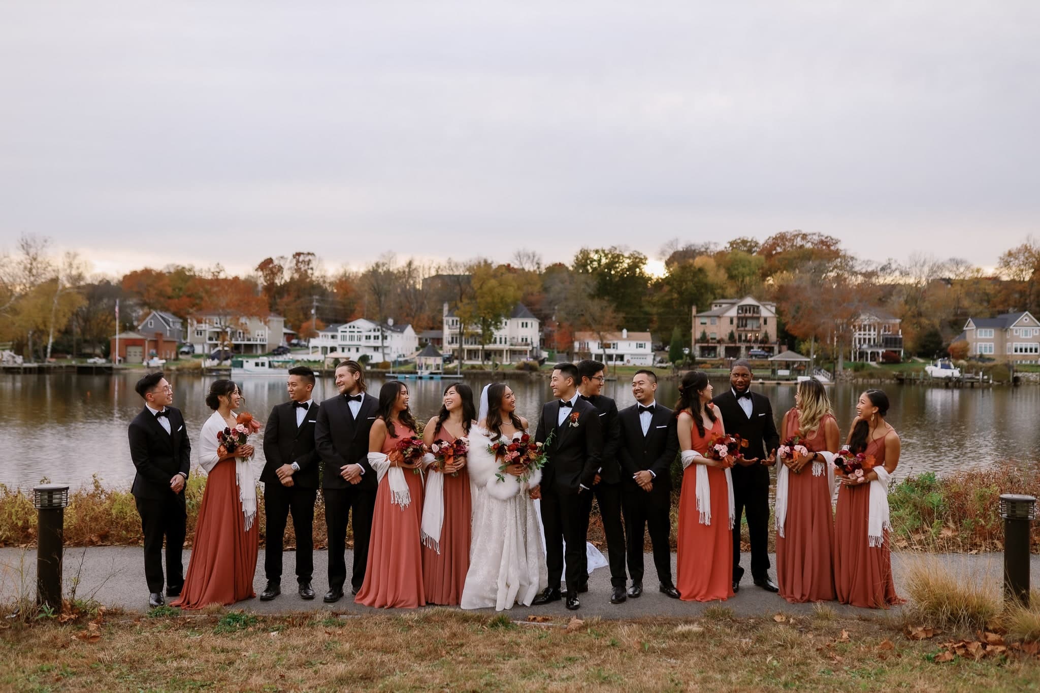 Wedding party lined up by the lake