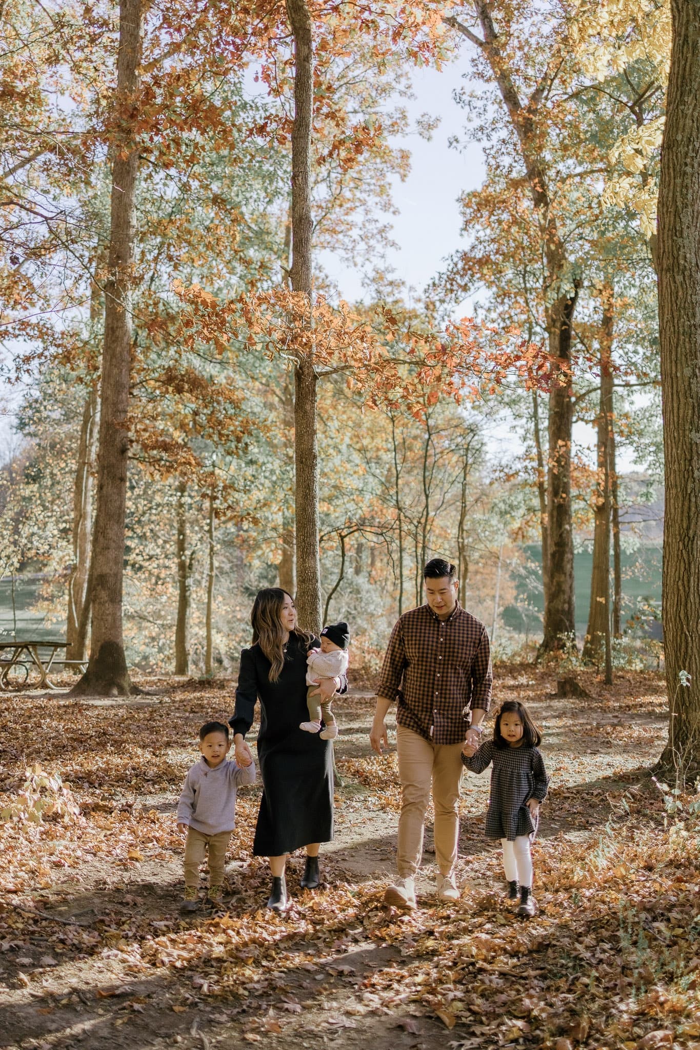 Family walking through tall autumn trees